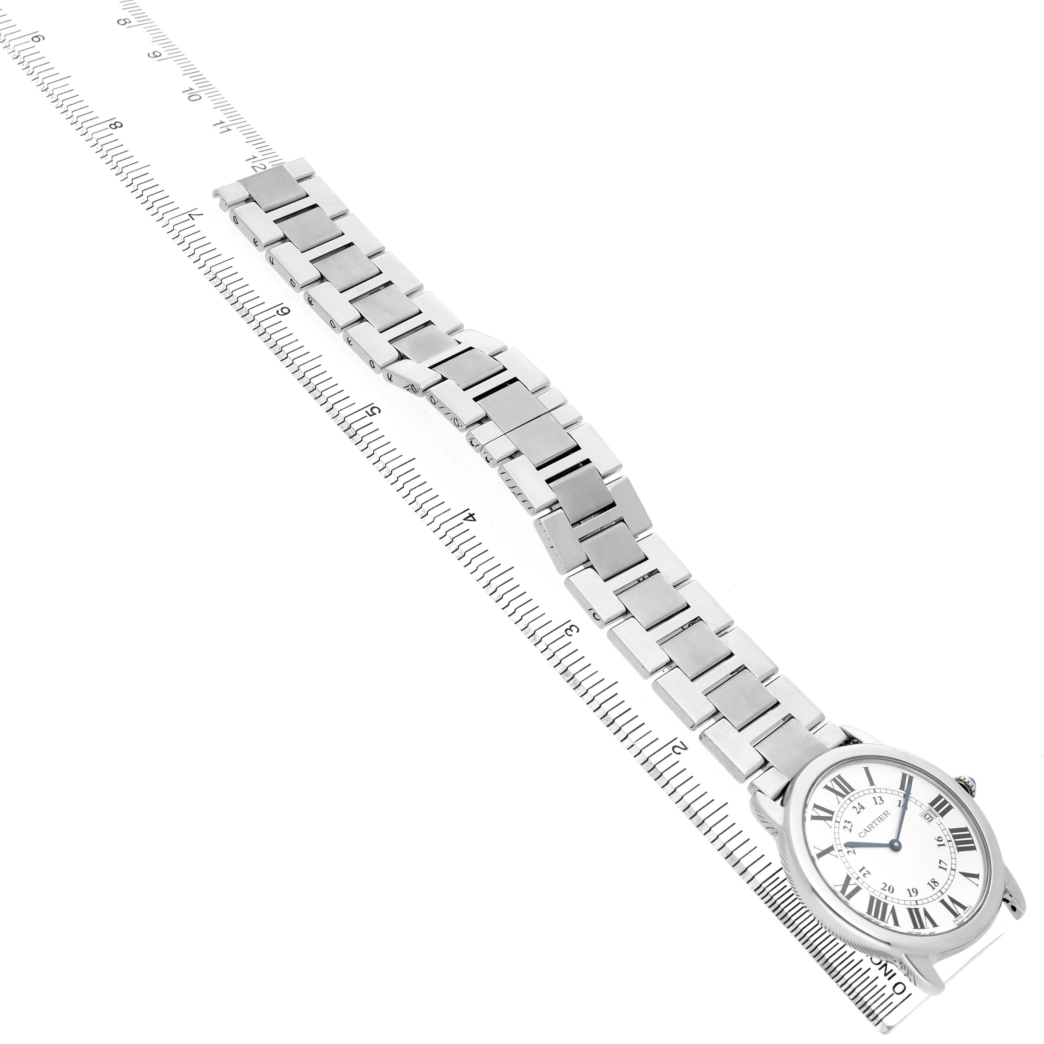 The Cartier Ronde W6701005 Men's Stainless Steel Silver Dial watch is shown from a top-down angle, with its full metal bracelet displayed alongside a ruler for scale.