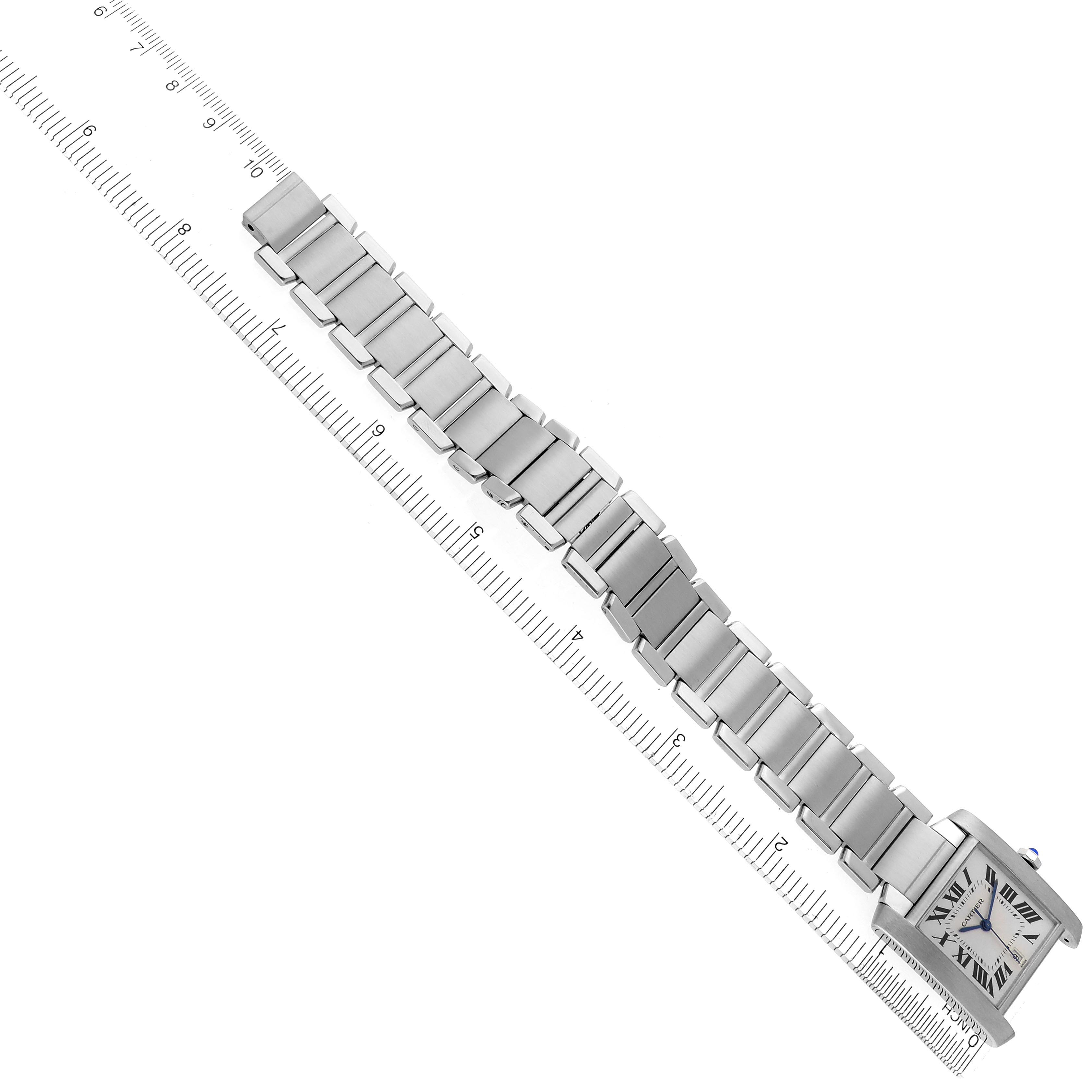The Cartier Tank Française watch is shown from an overhead angle, highlighting the full bracelet and rectangular face.
