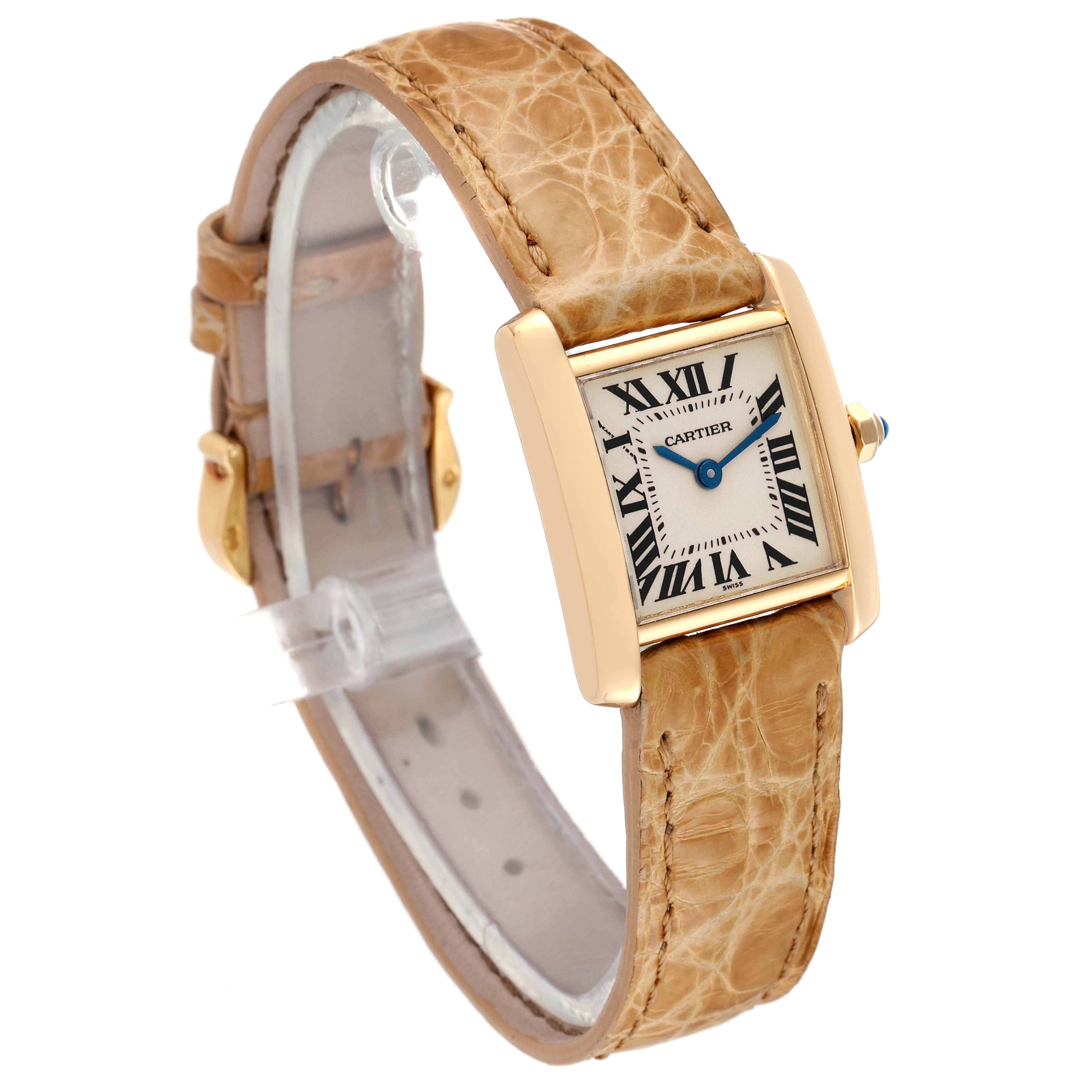 This image shows a Cartier Tank Francaise W5000256 Women
s Yellow Gold Silver Dial W5000256 Women
s Yellow Gold Silver Dial watch with a gold rectangular case and a tan leather strap, viewed at an angled perspective.