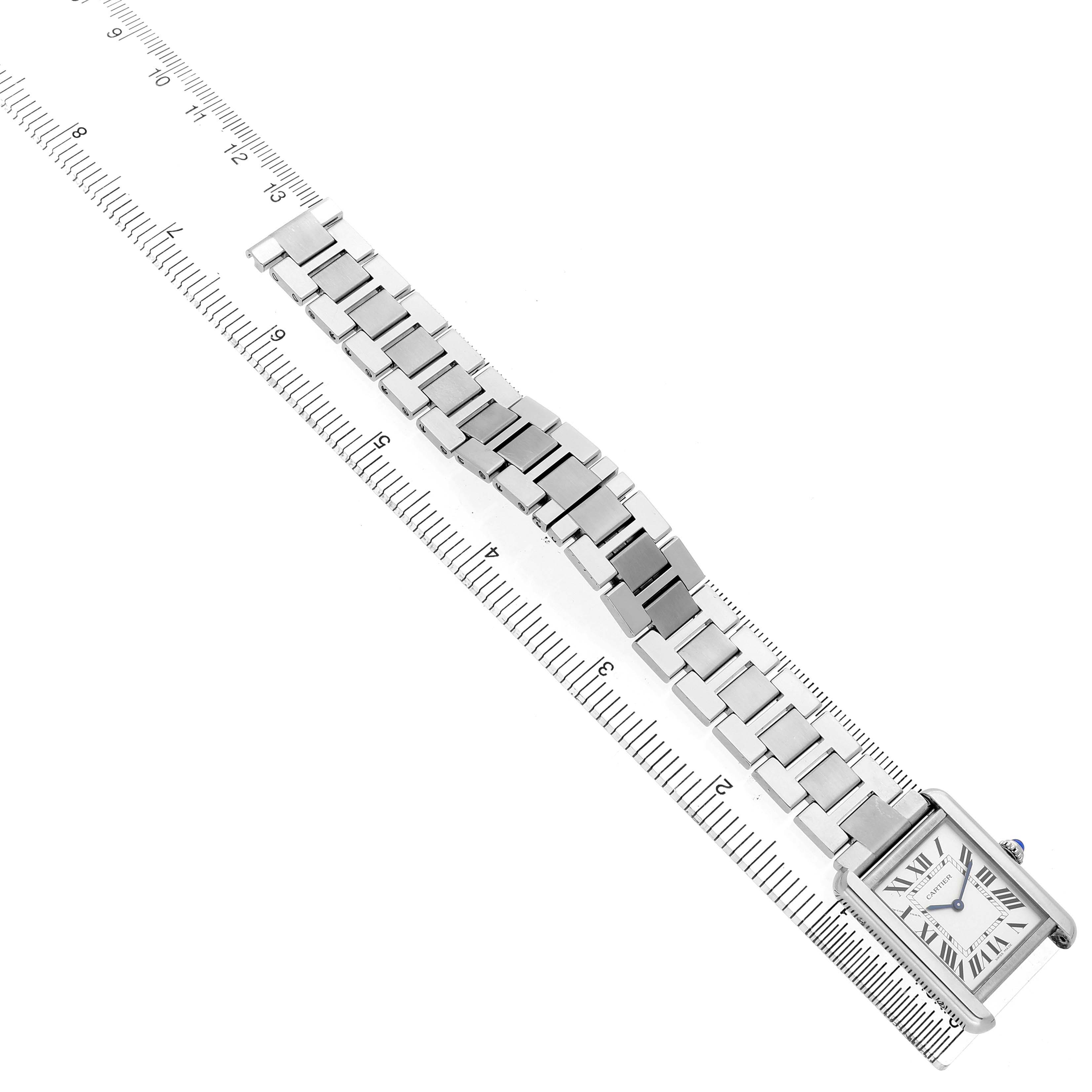 The Cartier Tank Solo W5200013 Women's Stainless Steel Silver Dial watch is shown at an overhead angle with its face and bracelet aligned along a ruler.