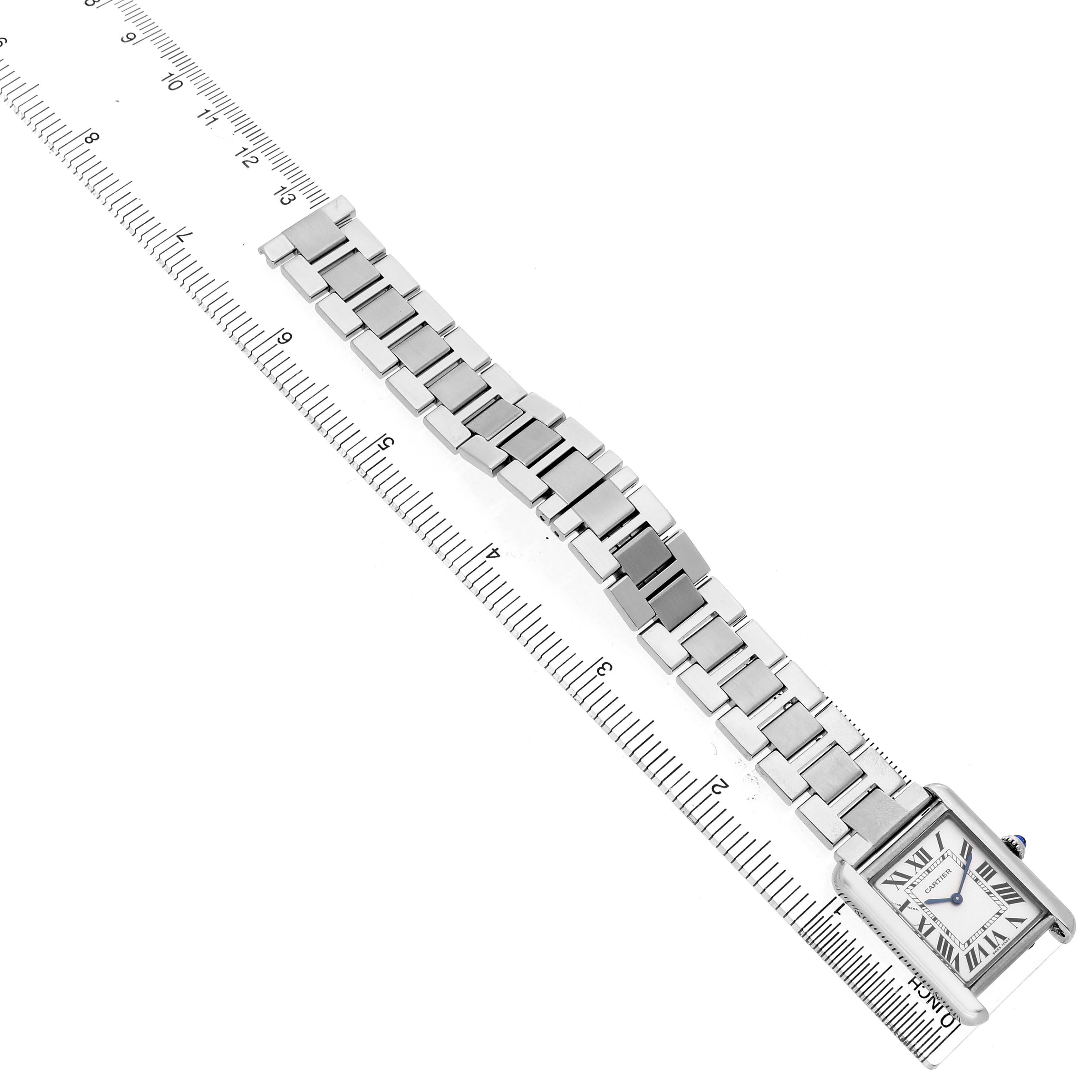 The image shows a Cartier Tank Solo W5200013 Women's Stainless Steel Silver Dial watch at an angle with its full bracelet and face alongside a ruler for size reference.