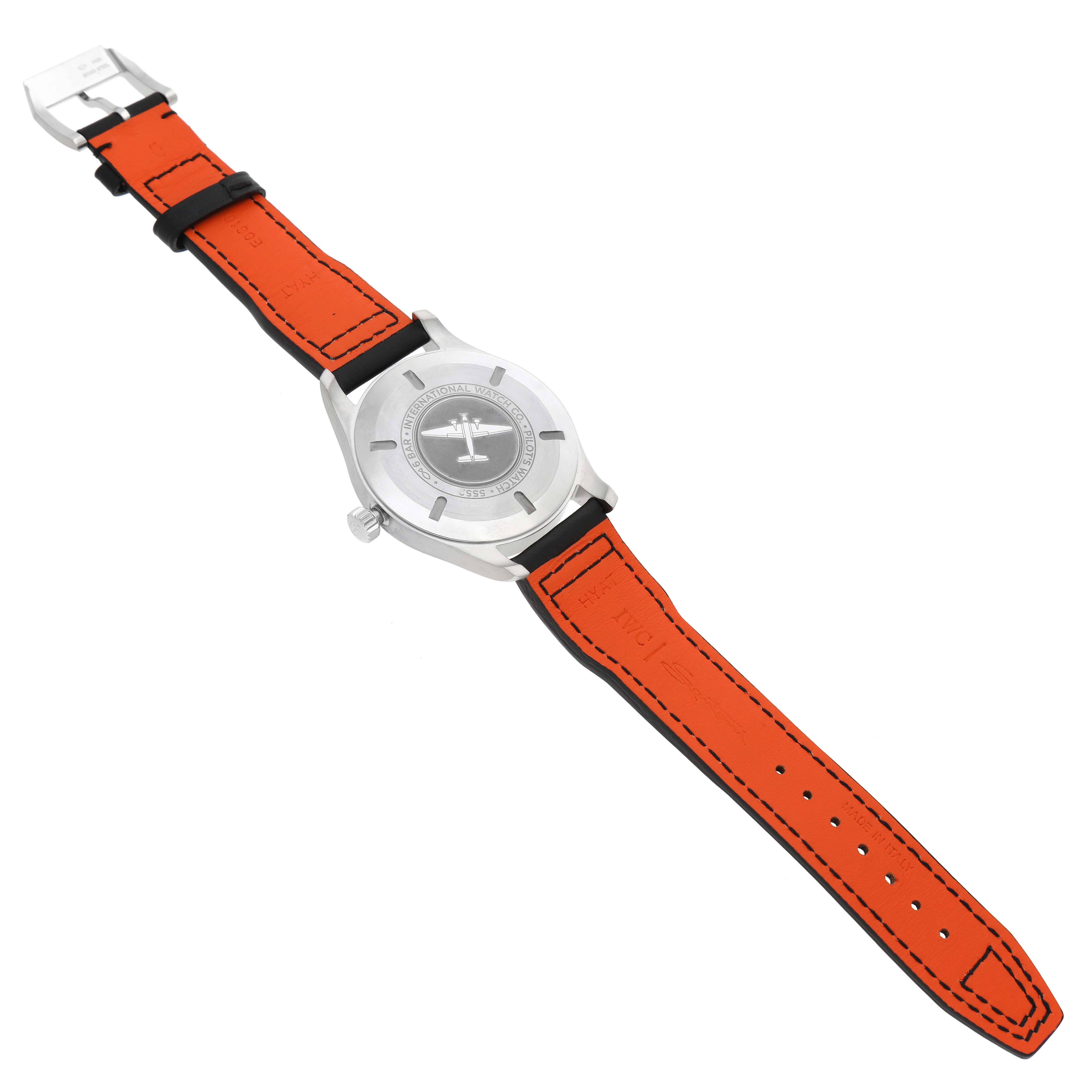 The IWC Pilot IW327001 Men's Stainless Steel Black Dial model is shown from the back, highlighting the case back and orange strap with stitching and a buckle.