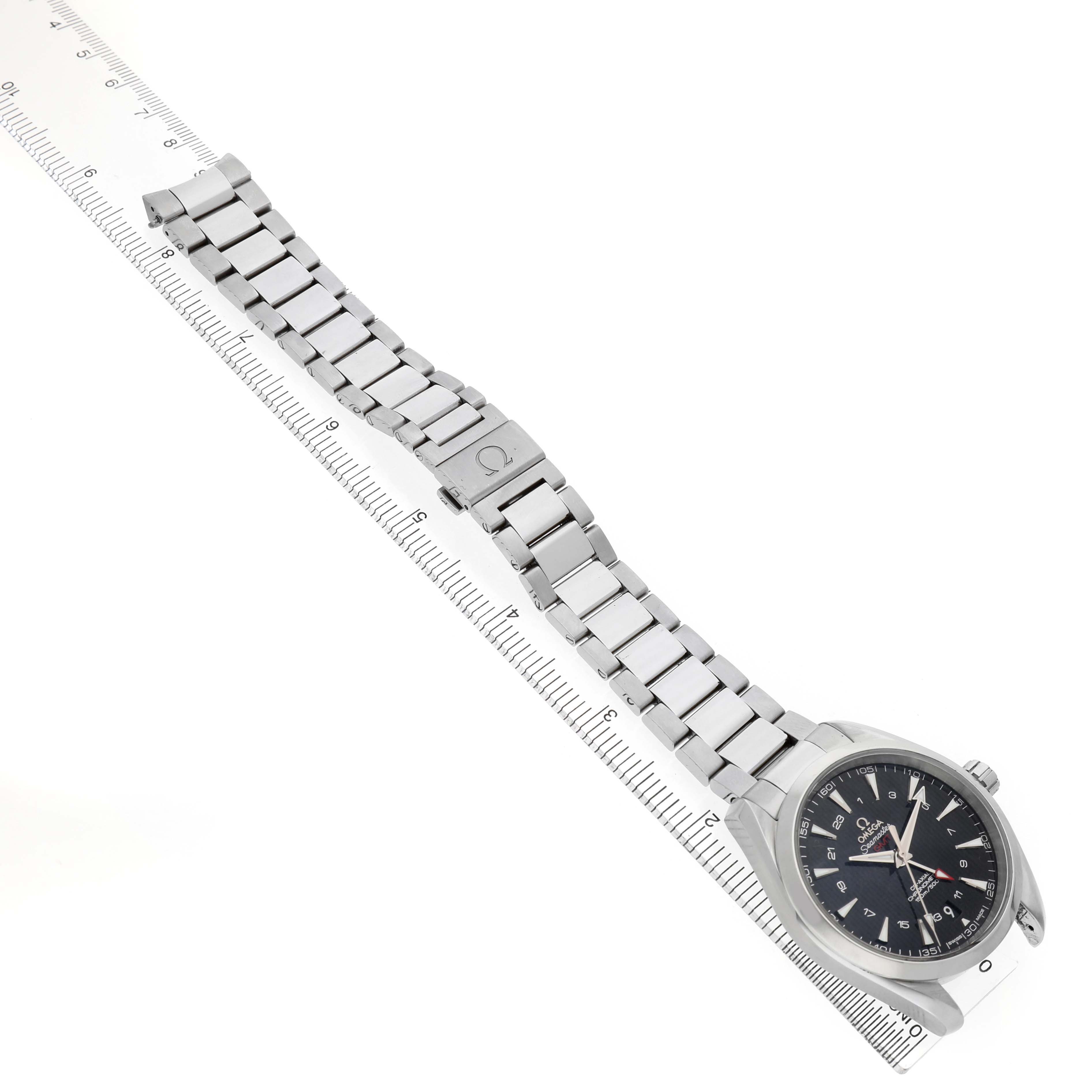 The Omega Speedmaster 231.10.43.22.01.001 Men's Stainless Steel Black Dial watch is shown from a top angle, highlighting the face and full metal bracelet alongside a ruler.