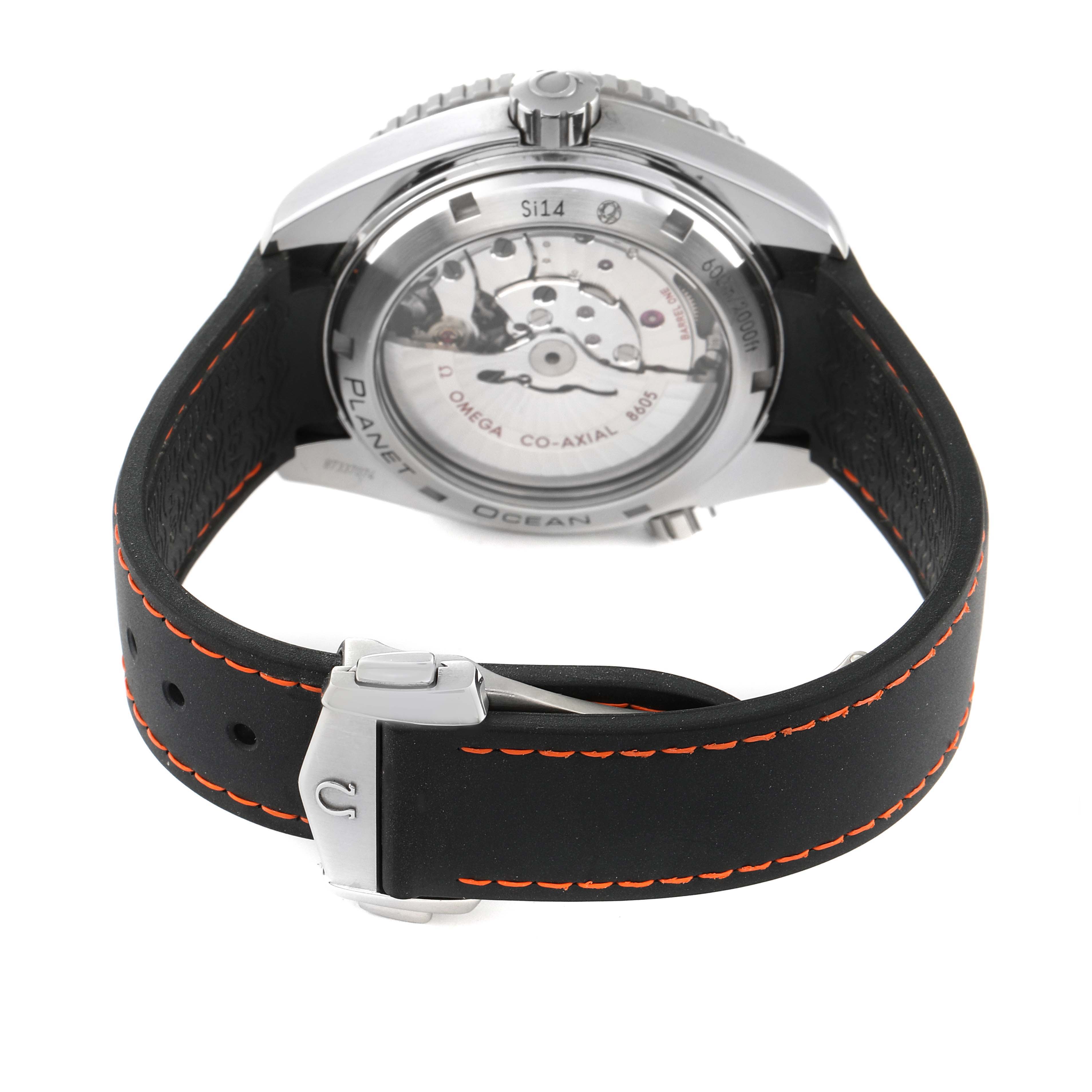 The image shows the back view of an Omega Planet Ocean 232.32.44.22.01.002 Men
s Stainless Steel Black Dial 232.32.44.22.01.002 Men
s Stainless Steel Black Dial watch, highlighting the movement and the strap with orange stitching.
