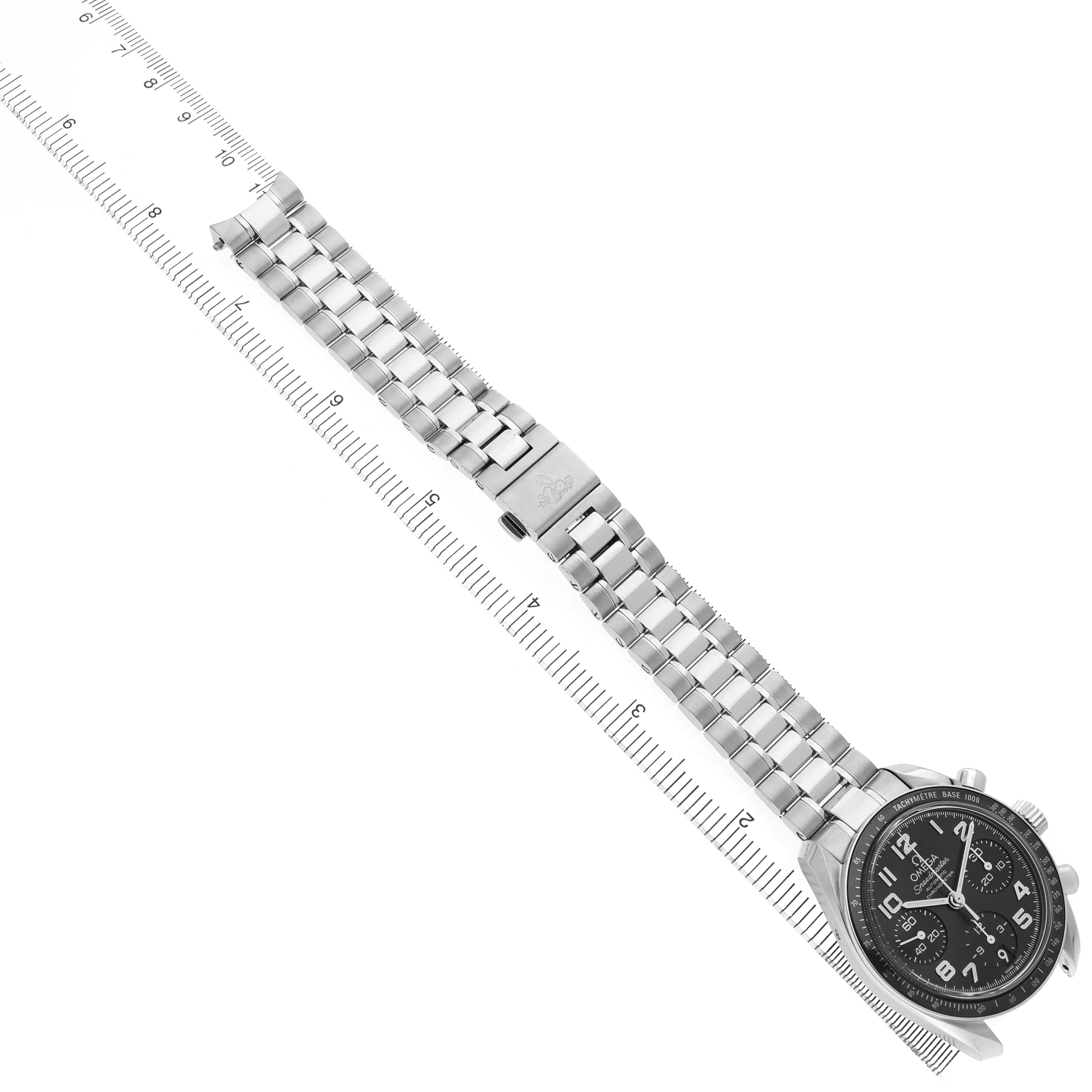 The Omega Speedmaster 324.30.38.40.06.001 Men's Stainless Steel Grey Dial watch is shown at a slight angle, displaying its face, metal bracelet, and clasp, alongside a measuring ruler.