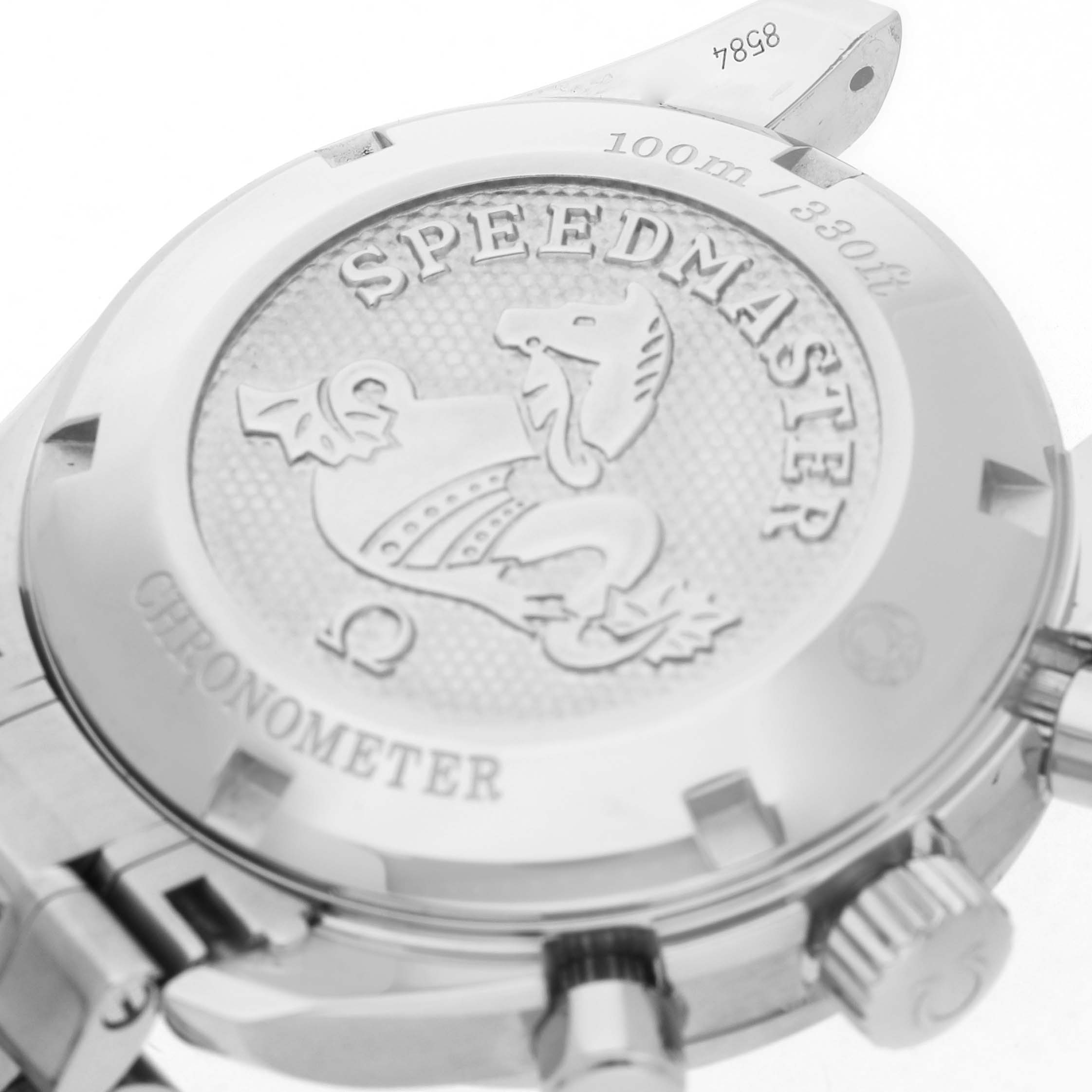 The image shows the case back of an Omega Speedmaster 324.30.38.40.06.001 Men's Stainless Steel Grey Dial watch, featuring the embossed logo and water resistance details.