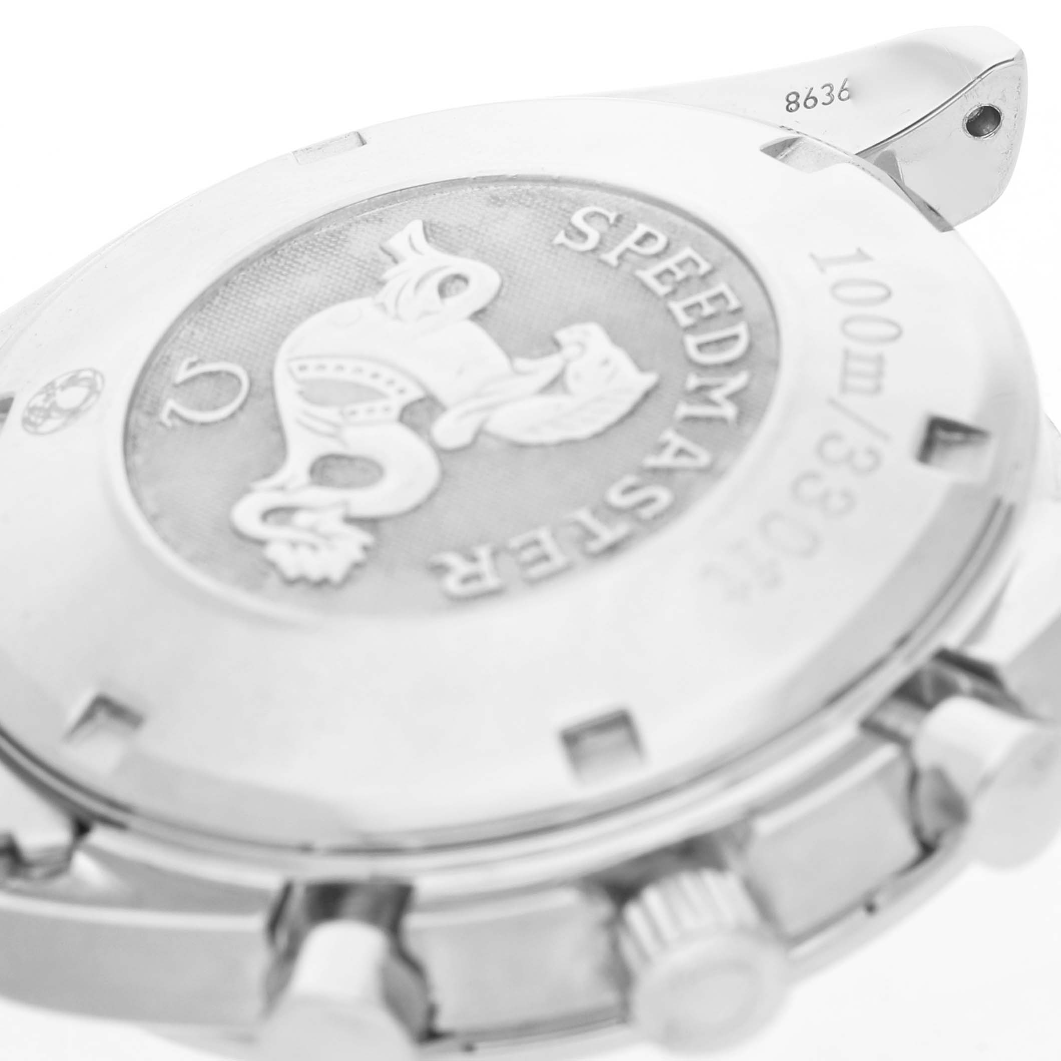 The image shows the case back of an Omega Speedmaster 3210.50.00 Men's Stainless Steel Black Dial, highlighting its emblem, engraving, and part of the crown.