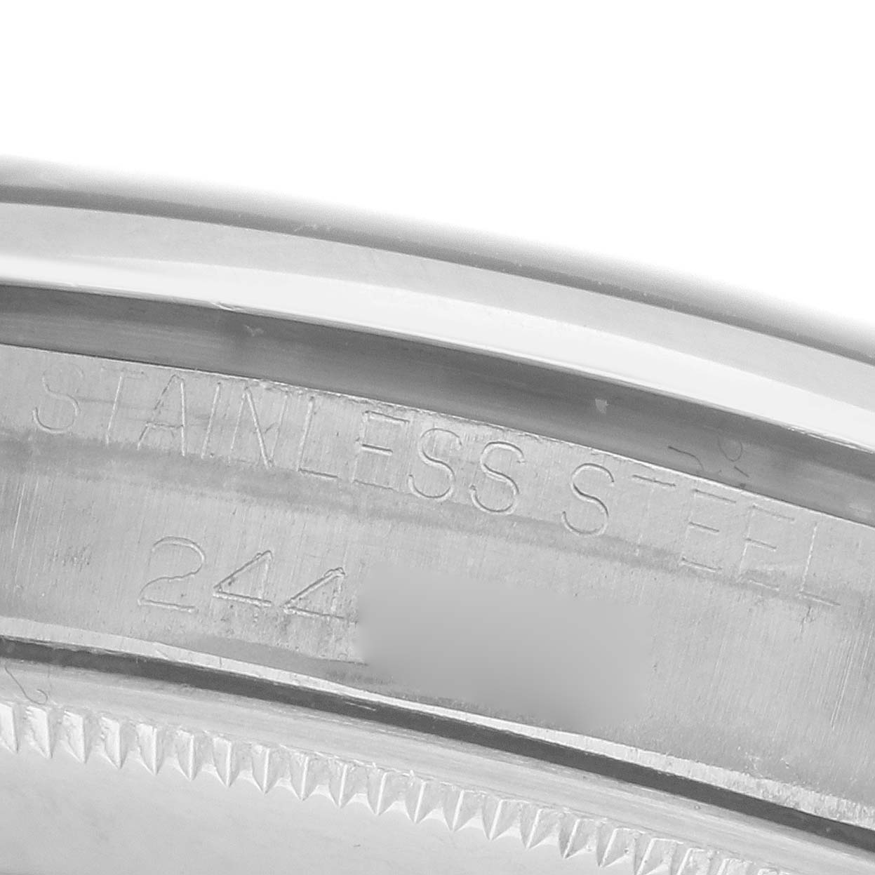 The image shows a close-up angle of the Rolex Air-King's stainless steel case back with engraved text.