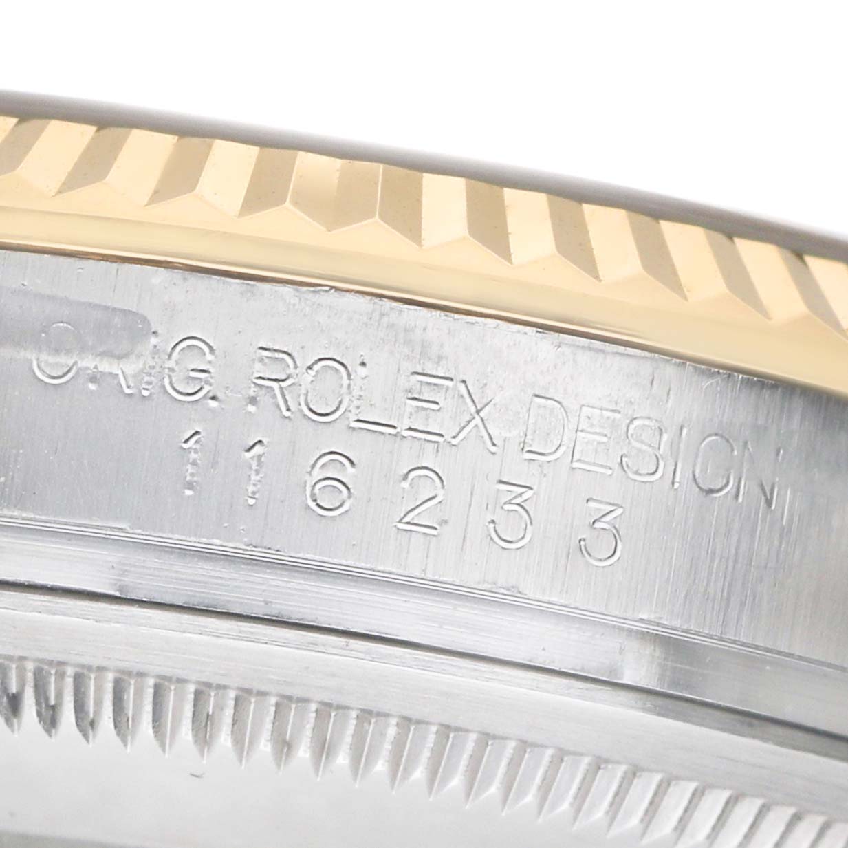 The image shows a close-up of the side of a Rolex Datejust 116233 Men's Steel and Gold (two tone) Grey Dial, featuring the fluted bezel and engraved serial details.