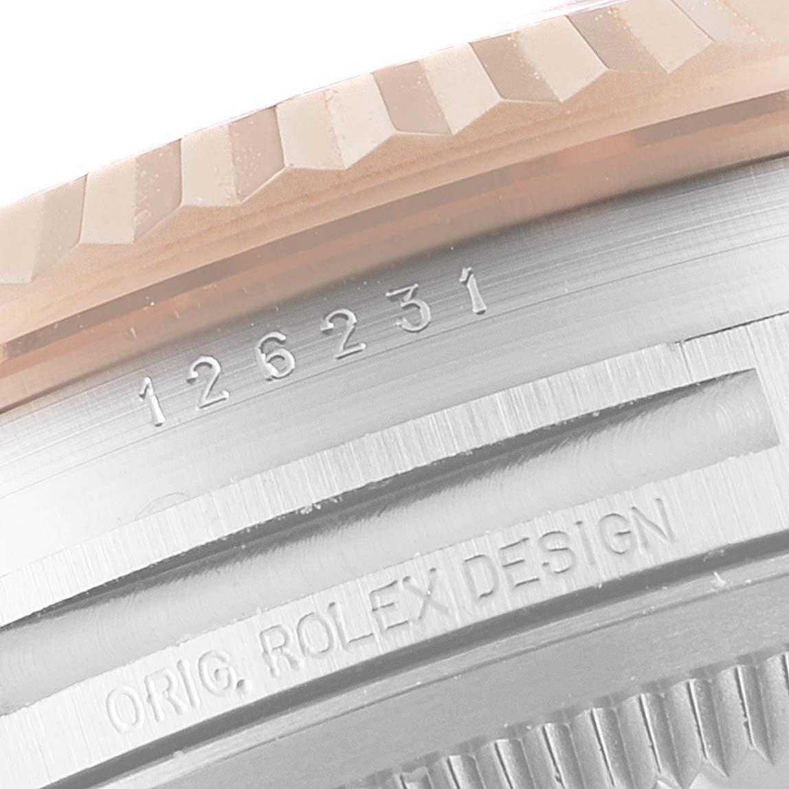 The image shows a close-up of the edge of a Rolex Datejust 126231 Men's Steel and Gold (two tone) White Dial 126231 Men's Steel and Gold (two tone) White Dial model, highlighting the case and bezel with the engraved serial number.