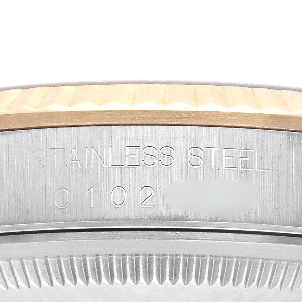 The image shows a close-up of the side engraving on a Rolex Datejust 16233 Men's Steel and Gold (two tone) Champagne Dial 16233 Men's Steel and Gold (two tone) Champagne Dial model, featuring "STAINLESS STEEL" and a partial serial number.
