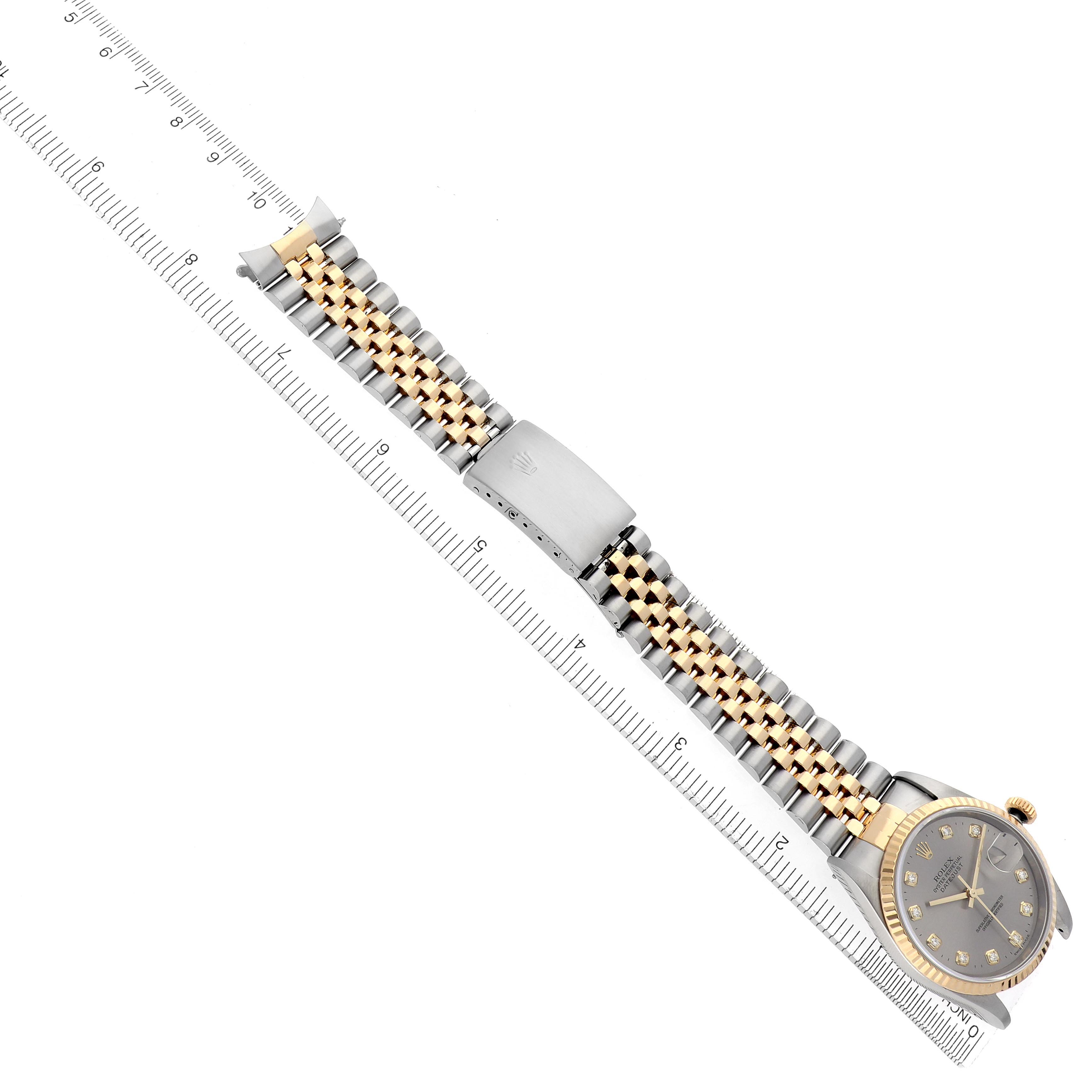 The image shows a Rolex Datejust 16233 Men's Steel and Gold (two tone) Silver Dial 16233 Men's Steel and Gold (two tone) Silver Dial watch at an angle, emphasizing the bracelet and clasp alongside a ruler for scale.
