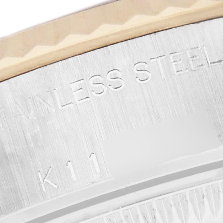 The image shows a close-up of the engraved text "STAINLESS STEEL" on the bezel edge of a Rolex Datejust 79173 Women's Steel and Gold (two tone) Mother of Pearl Dial 79173 Women's Steel and Gold (two tone) Mother of Pearl Dial watch.
