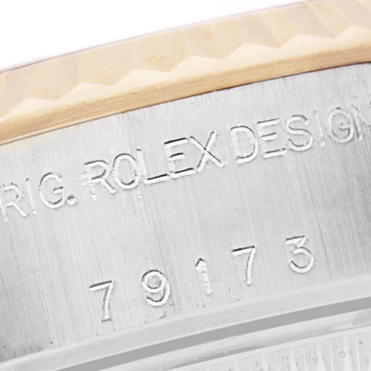 The image shows a close-up of the engraved bezel edge and serial number on a Rolex Datejust 79173 Women's Steel and Gold (two tone) Mother of Pearl Dial 79173 Women's Steel and Gold (two tone) Mother of Pearl Dial watch.