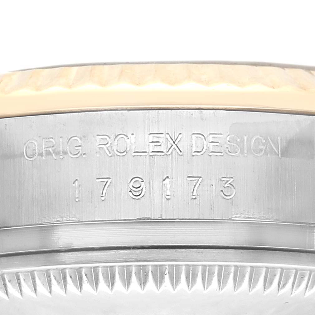 The image shows a close-up of the side of a Rolex Datejust 179173 Women's Steel and Gold (two tone) White Dial 179173 Women's Steel and Gold (two tone) White Dial watch, highlighting the engraved model number and design details.