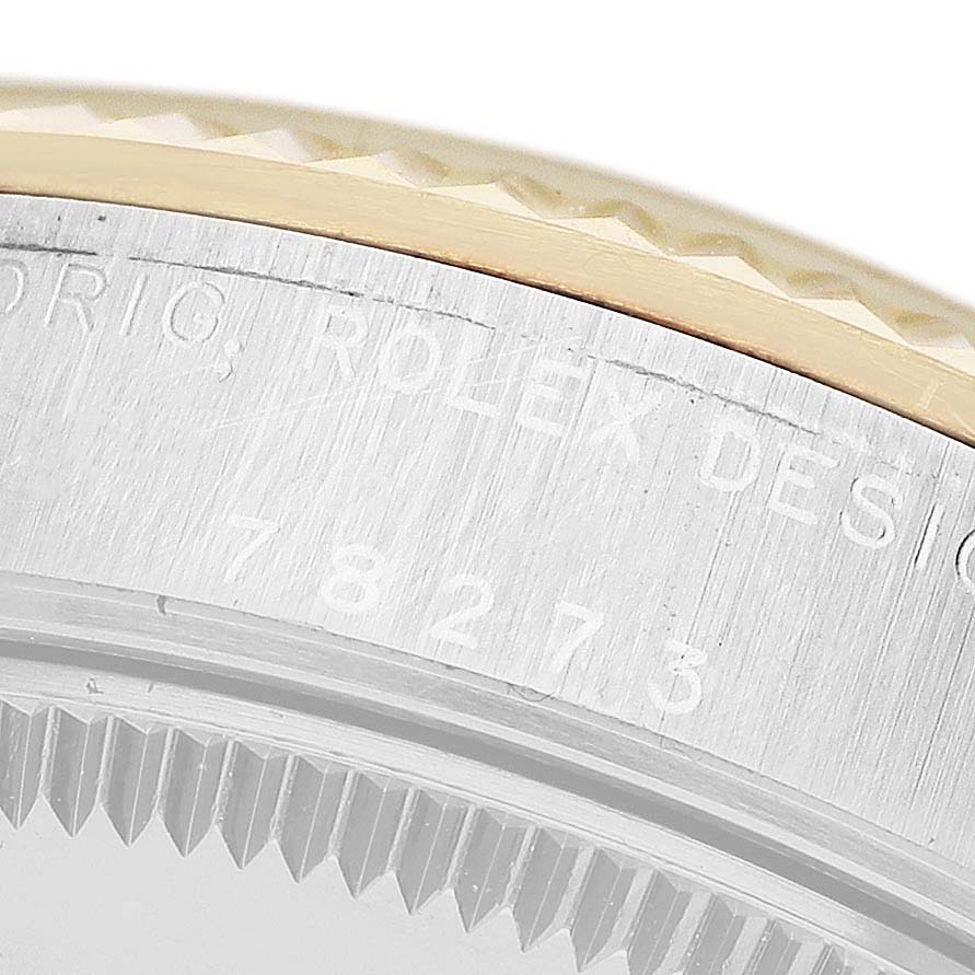 The image shows a close-up of the case and bezel edge of a Rolex Mid-Size 78273 Women's Steel and Gold (two tone) White Dial model, displaying engraved text.