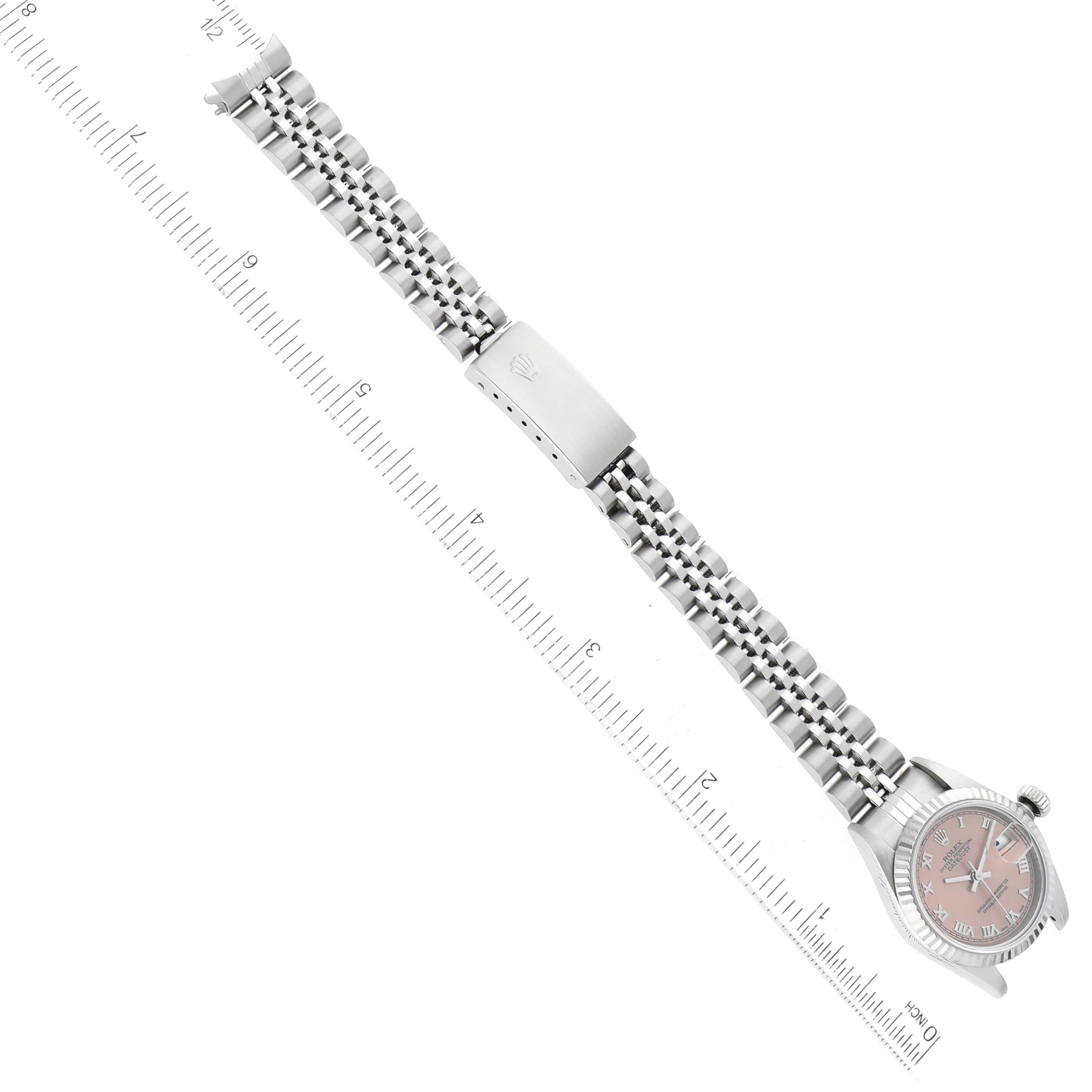 The Rolex Datejust 79174 Women's Stainless Steel Pink Dial 79174 Women's Stainless Steel Pink Dial watch is shown horizontally, featuring its full bracelet and closed clasp, with a ruler for scale.