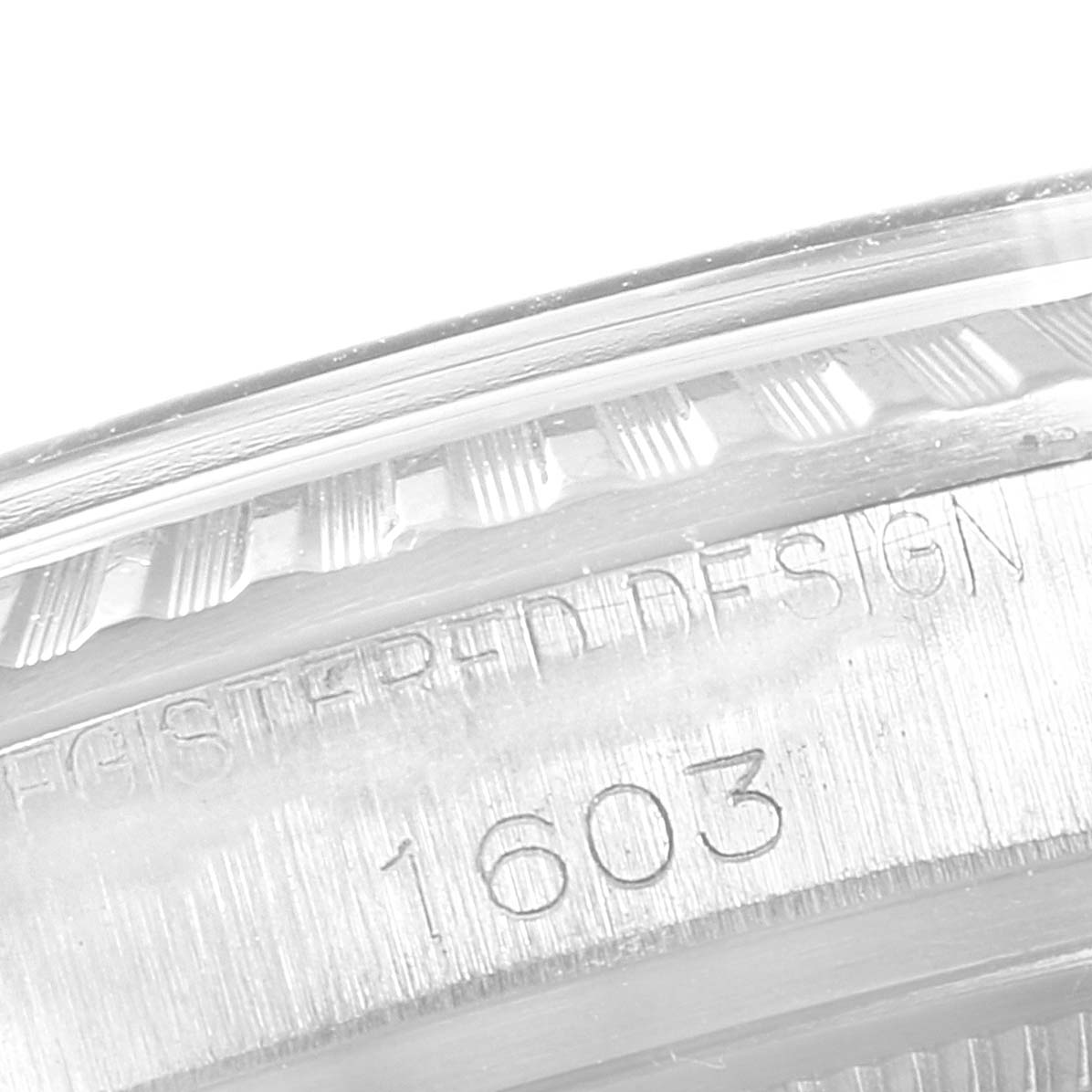 This image shows the engraved serial number and part of the bezel of a Rolex Vintage Collection 1603 Men
s Stainless Steel Silver Dial 1603 Men
s Stainless Steel Silver Dial watch, model 1603.