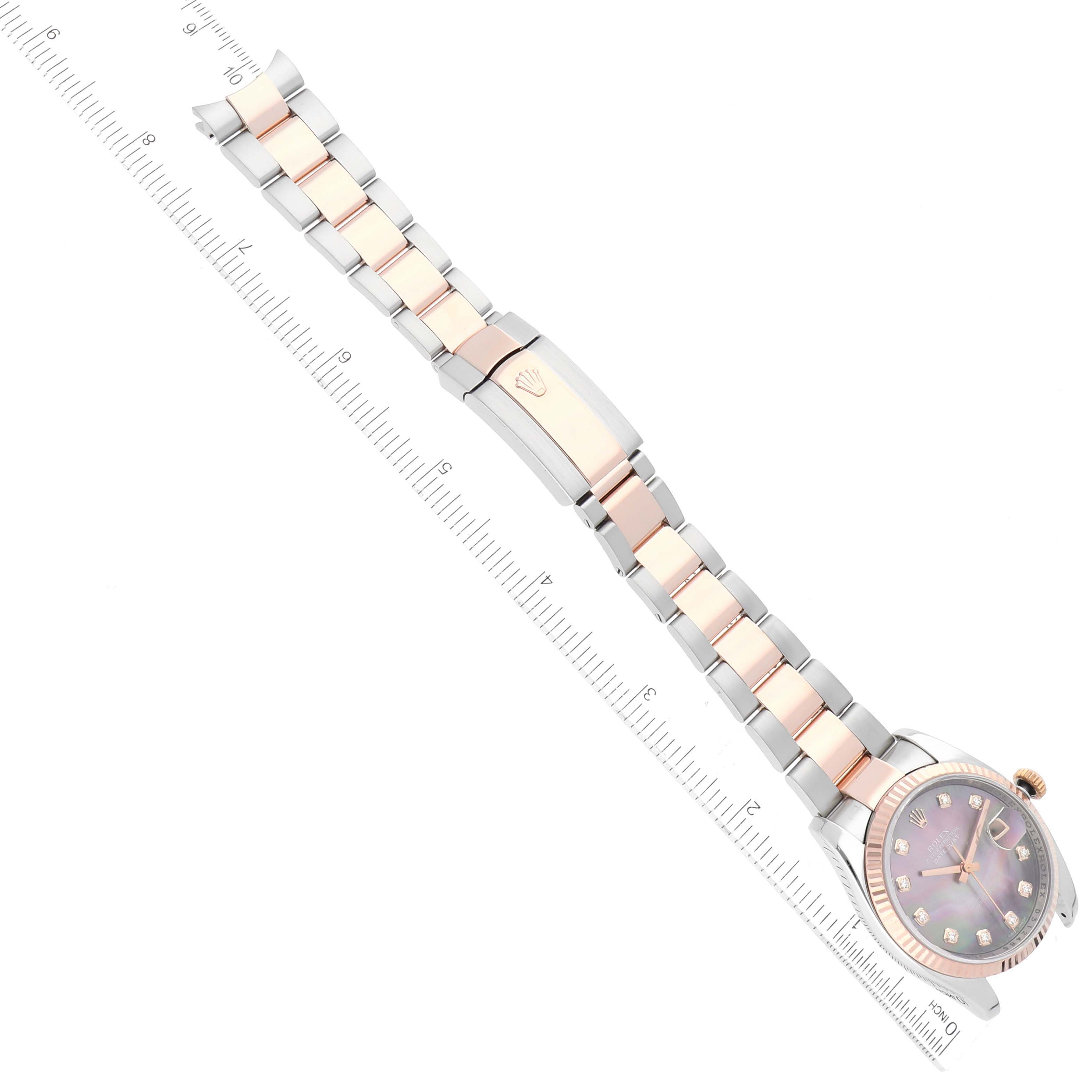 The image shows a top-down view of a Rolex Datejust 116231 Men's Steel and Gold (two tone) Mother of Pearl Dial 116231 Men's Steel and Gold (two tone) Mother of Pearl Dial watch, highlighting its bracelet and face alongside a ruler.