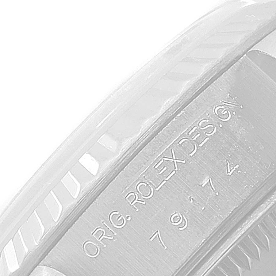 The image shows a close-up of the bezel and case side of a Rolex Datejust 79174 Women's Stainless Steel Black Dial 79174 Women's Stainless Steel Black Dial model with engraving visible.