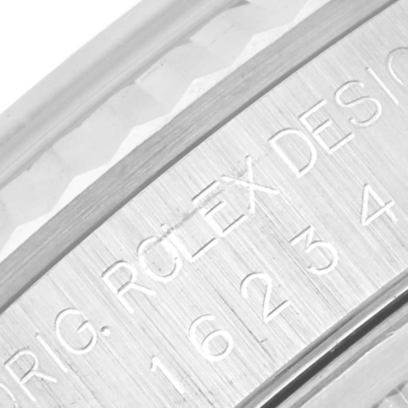This close-up image shows the engraved serial number and part of the fluted bezel of the Rolex Datejust 16234G Men's Stainless Steel Mother of Pearl Dial 16234G Men's Stainless Steel Mother of Pearl Dial watch.