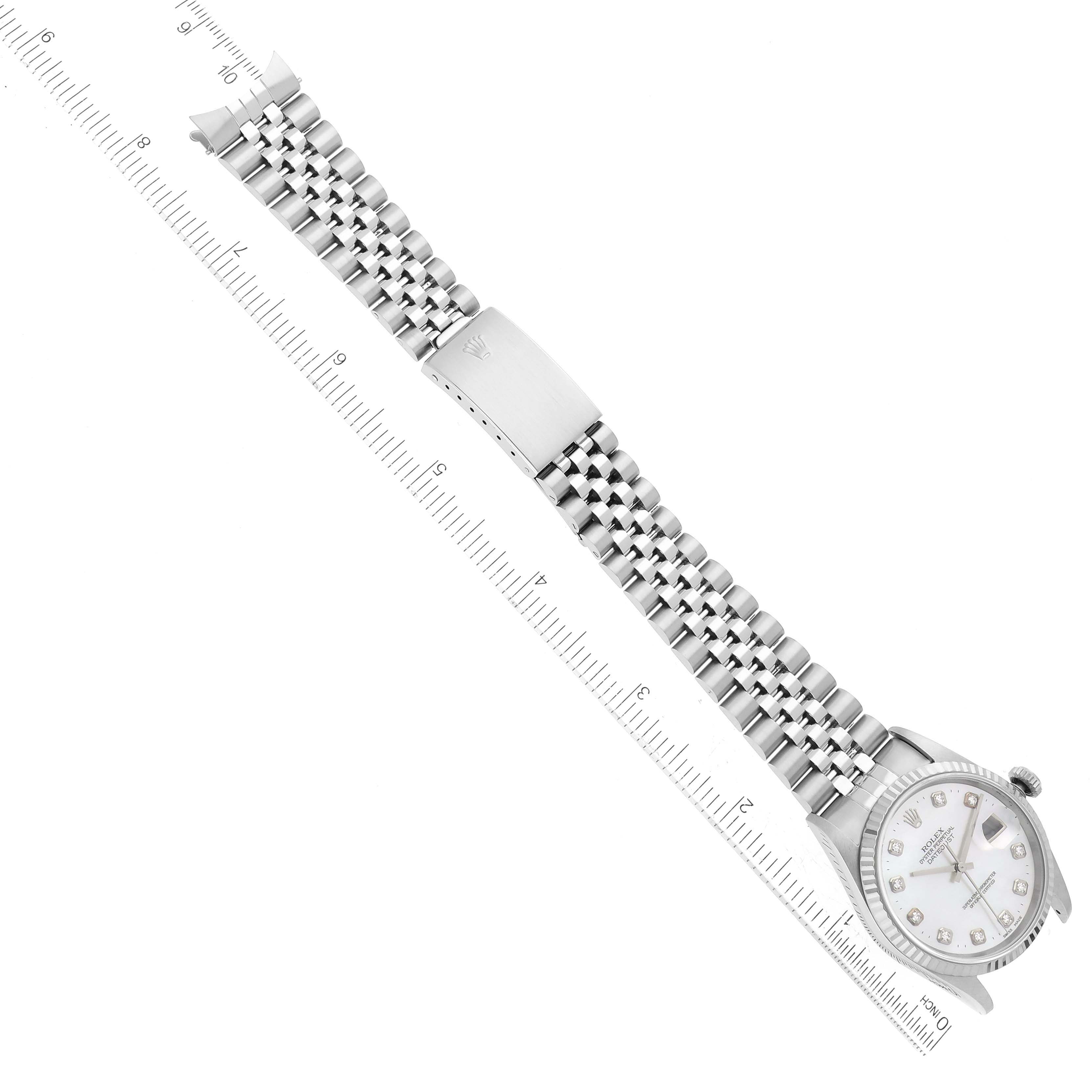 The image shows a Rolex Datejust 16234G Men's Stainless Steel Mother of Pearl Dial 16234G Men's Stainless Steel Mother of Pearl Dial watch laid flat beside a ruler, displaying the dial, bracelet, and clasp.