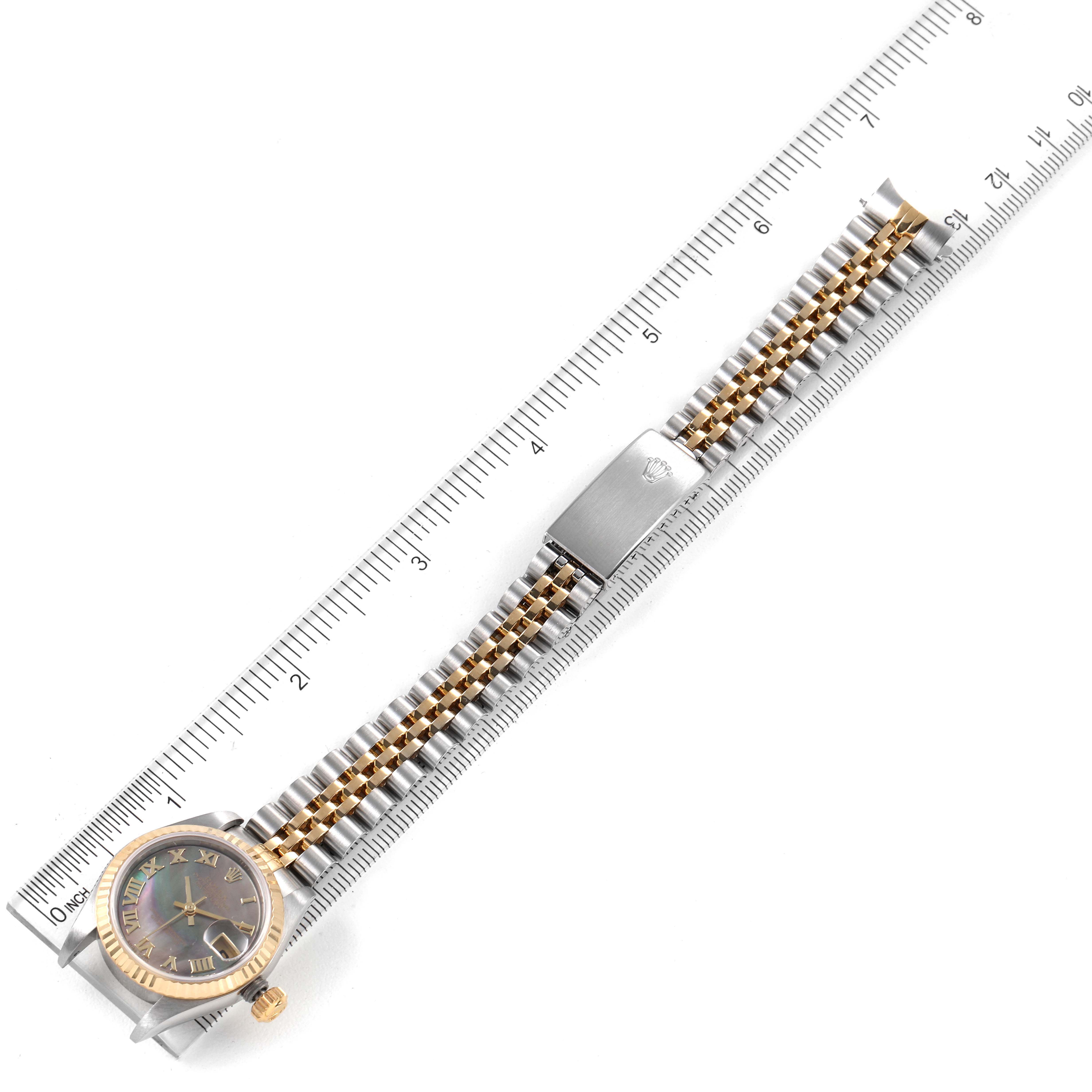 The image shows a Rolex Datejust 79173 Women's Steel and Gold (two tone) Mother of Pearl Dial 79173 Women's Steel and Gold (two tone) Mother of Pearl Dial watch from a top-down angle, with a ruler for scale alongside the watch and its band.
