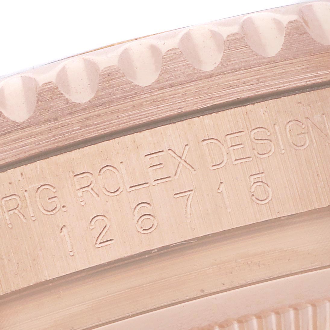 The image shows a close-up of the side of a Rolex GMT-Master 126715CHNR Men
s Rose Gold Black Dial 126715CHNR Men
s Rose Gold Black Dial, highlighting the model
s engraved design details.