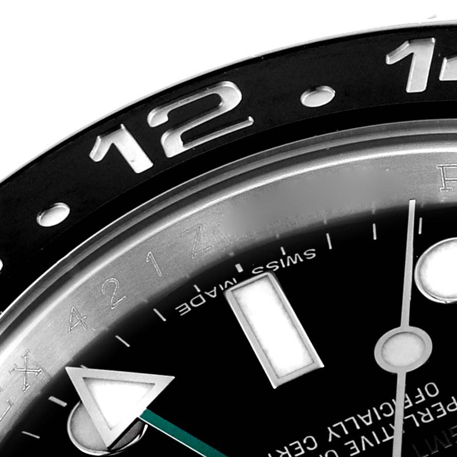 This close-up image of a Rolex GMT-Master 116710 Men's Stainless Steel Black Dial 116710 Men's Stainless Steel Black Dial watch shows the upper bezel and part of the dial with hour markers and hands.