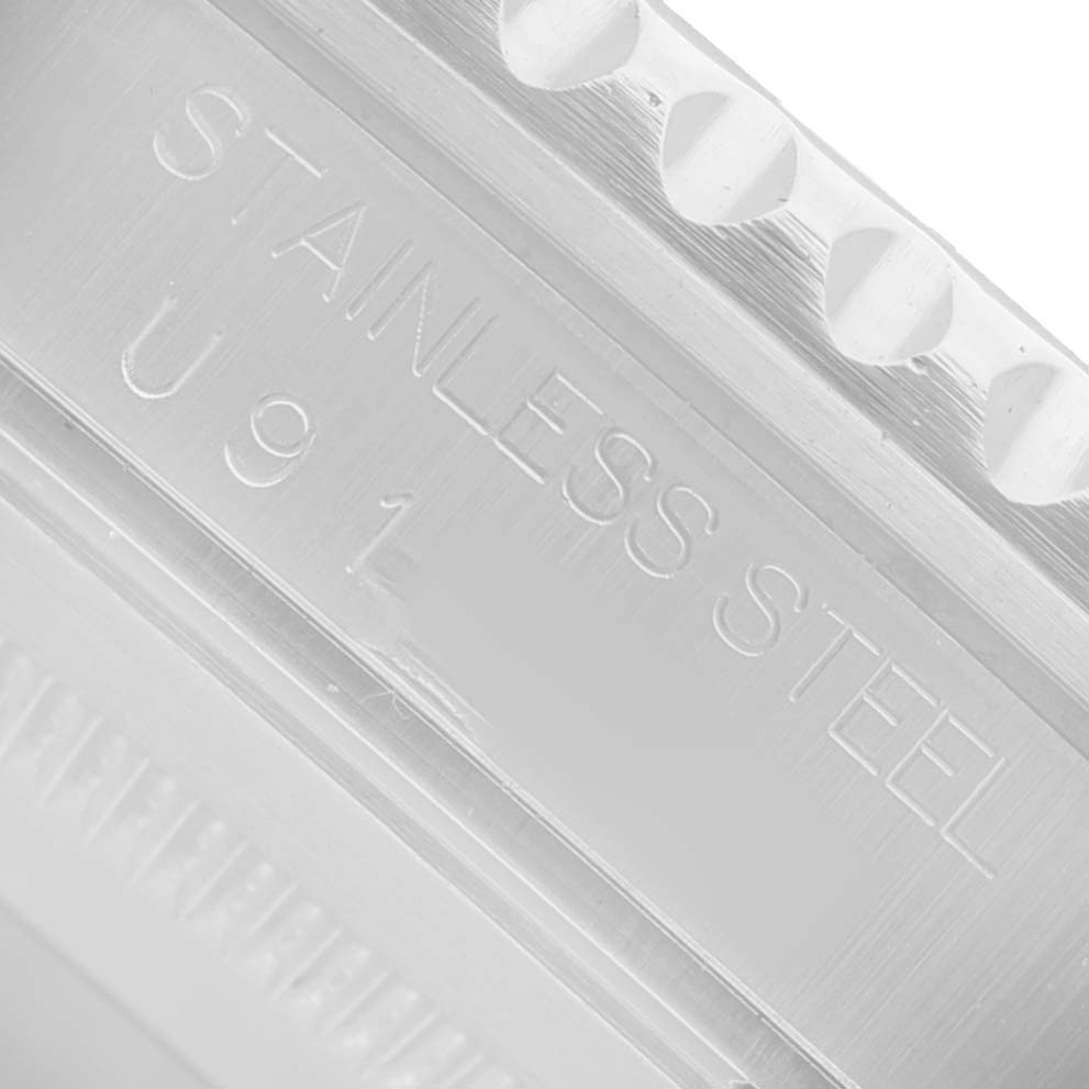 The image shows a close-up of the stainless steel case with engraved text, focusing on the Rolex GMT-Master 16700 Men's Stainless Steel Black Dial watch component.