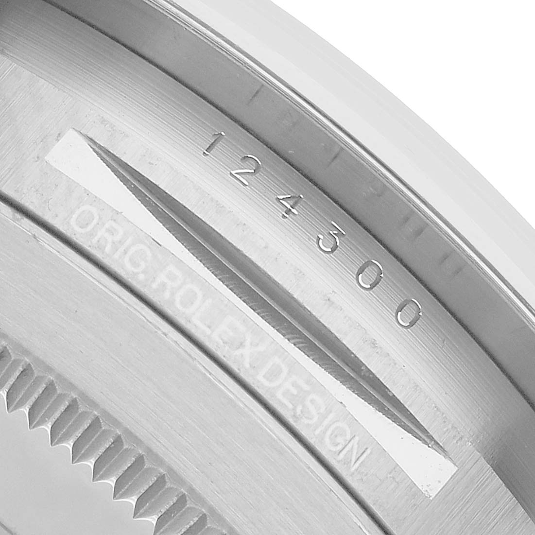 The image shows a close-up of the Rolex Oyster Perpetual 124300 Men's Stainless Steel Silver Dial's case edge, highlighting the model number and design engraving.