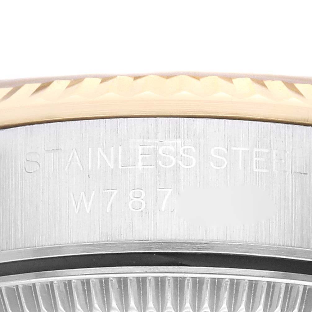 This close-up image displays the edge of the bezel and part of the case body with engraving, including the serial number, of a Rolex Oyster Perpetual 67193 Women's Steel and Gold (two tone) Champagne Dial 67193 Women's Steel and Gold (two tone) Champagne Dial watch.