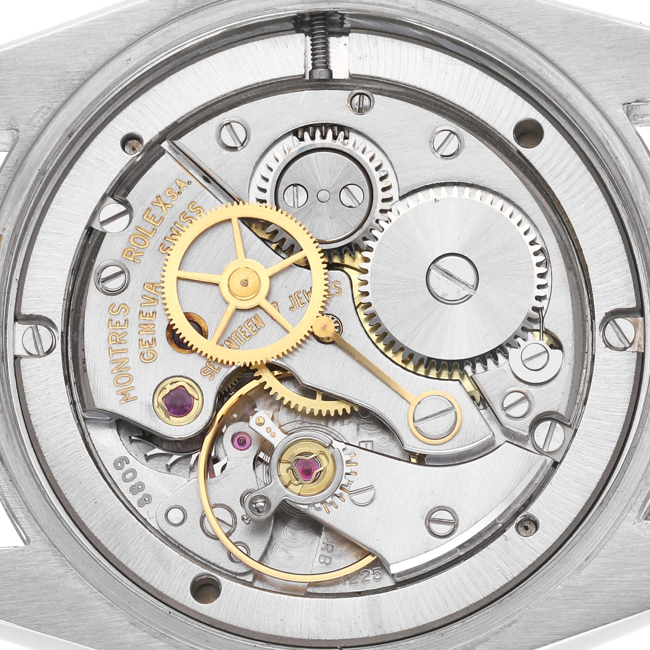 The image shows the movement of a Rolex Date 6694 Men's Stainless Steel Black Dial model, highlighting gears, jewels, and inscriptions from a top-down angle.
