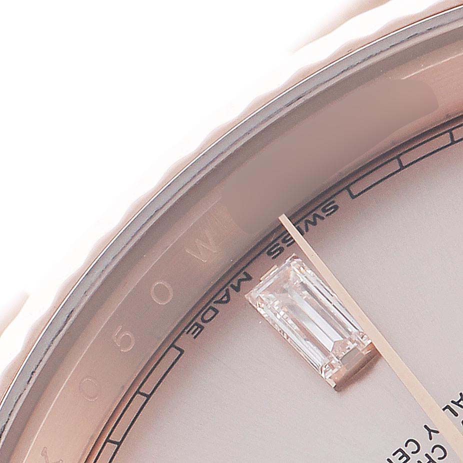 This close-up angle of the Rolex President 228235 Men's Rose Gold Pink Dial 228235 Men's Rose Gold Pink Dial watch shows part of the dial, a diamond hour marker, and a portion of the bezel.
