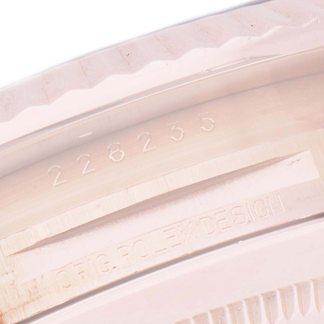 The image shows a close-up of the Rolex President 228235 Men's Rose Gold Pink Dial 228235 Men's Rose Gold Pink Dial model's inner bezel with engraved numbers and text.
