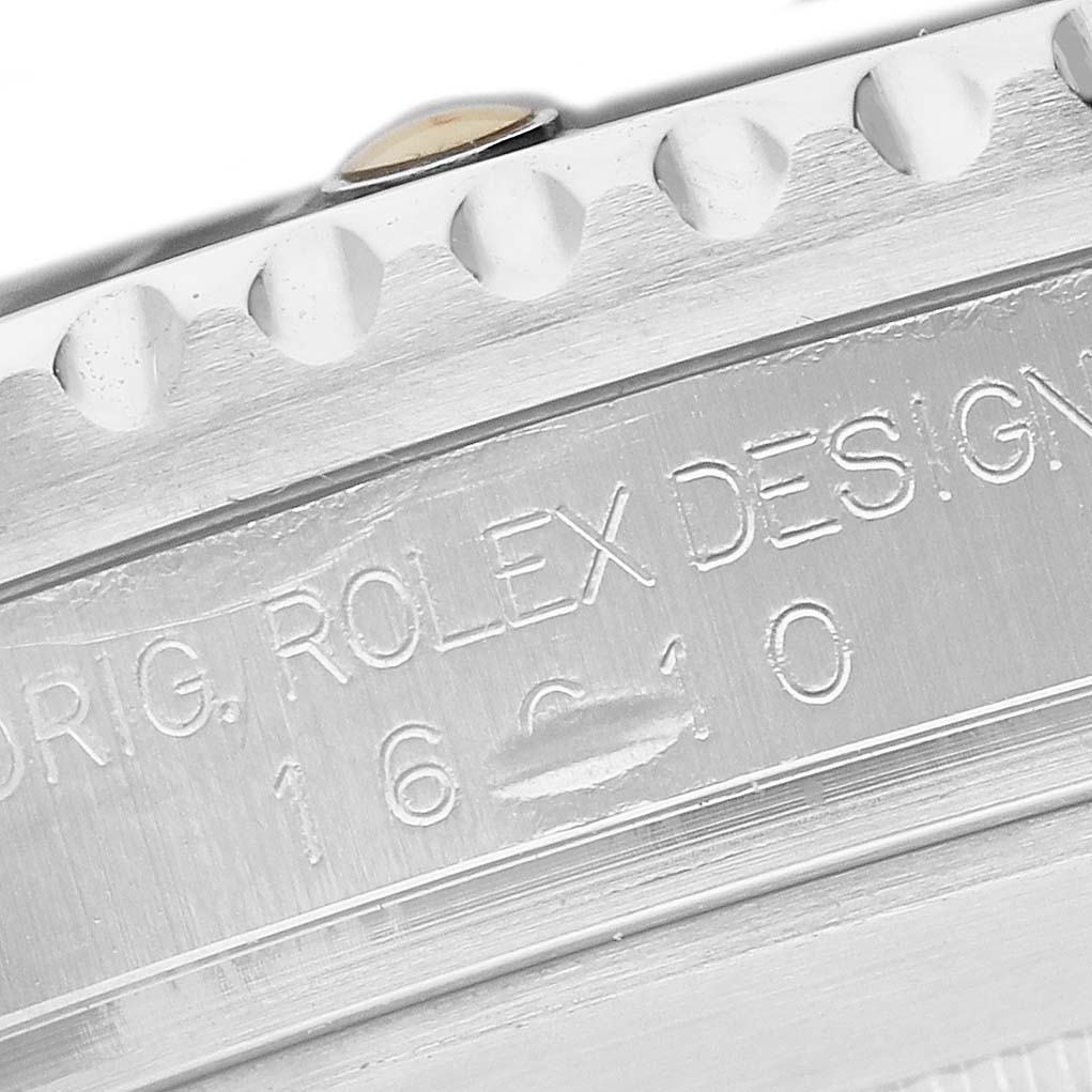 The image shows a close-up of the case side of a Rolex Submariner 16610 Men's Stainless Steel Black Dial, featuring the textured edge and engraved model information.