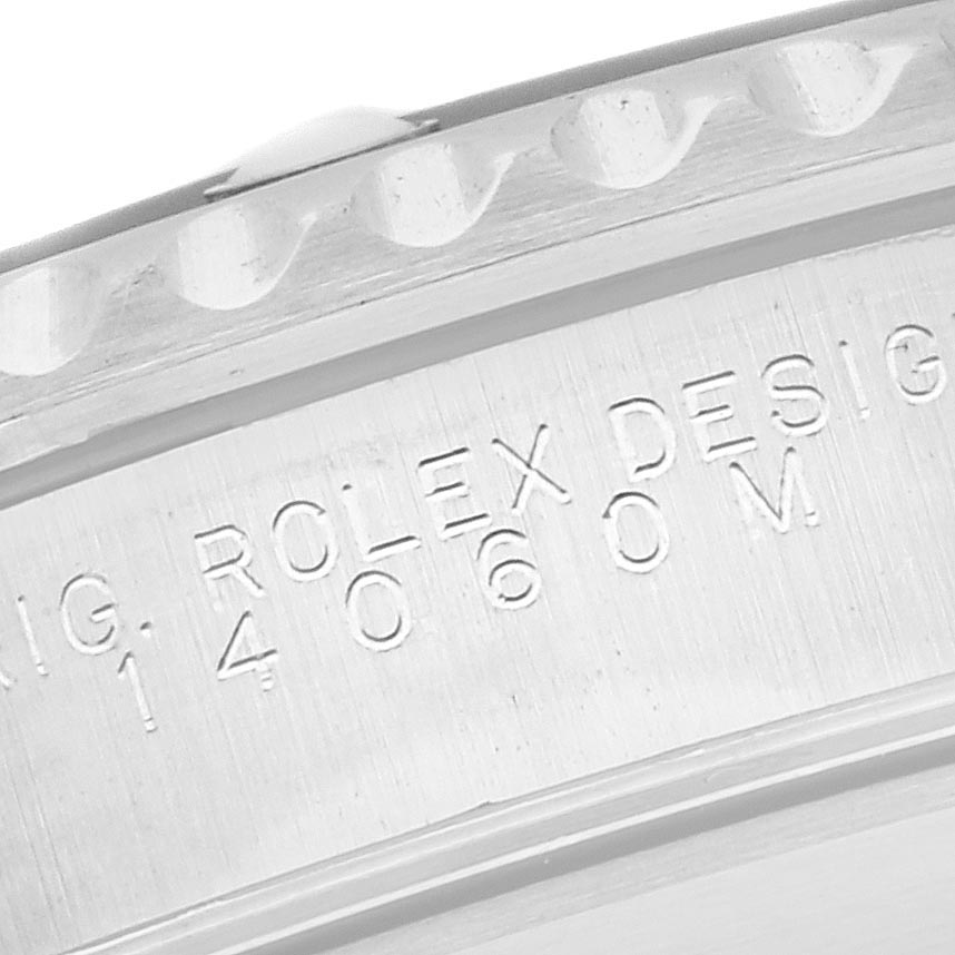 The image shows an angled close-up of the engraved lug or case side of a Rolex Submariner 14060 Men's Stainless Steel Black Dial 14060 Men's Stainless Steel Black Dial, displaying serial numbers and design text.