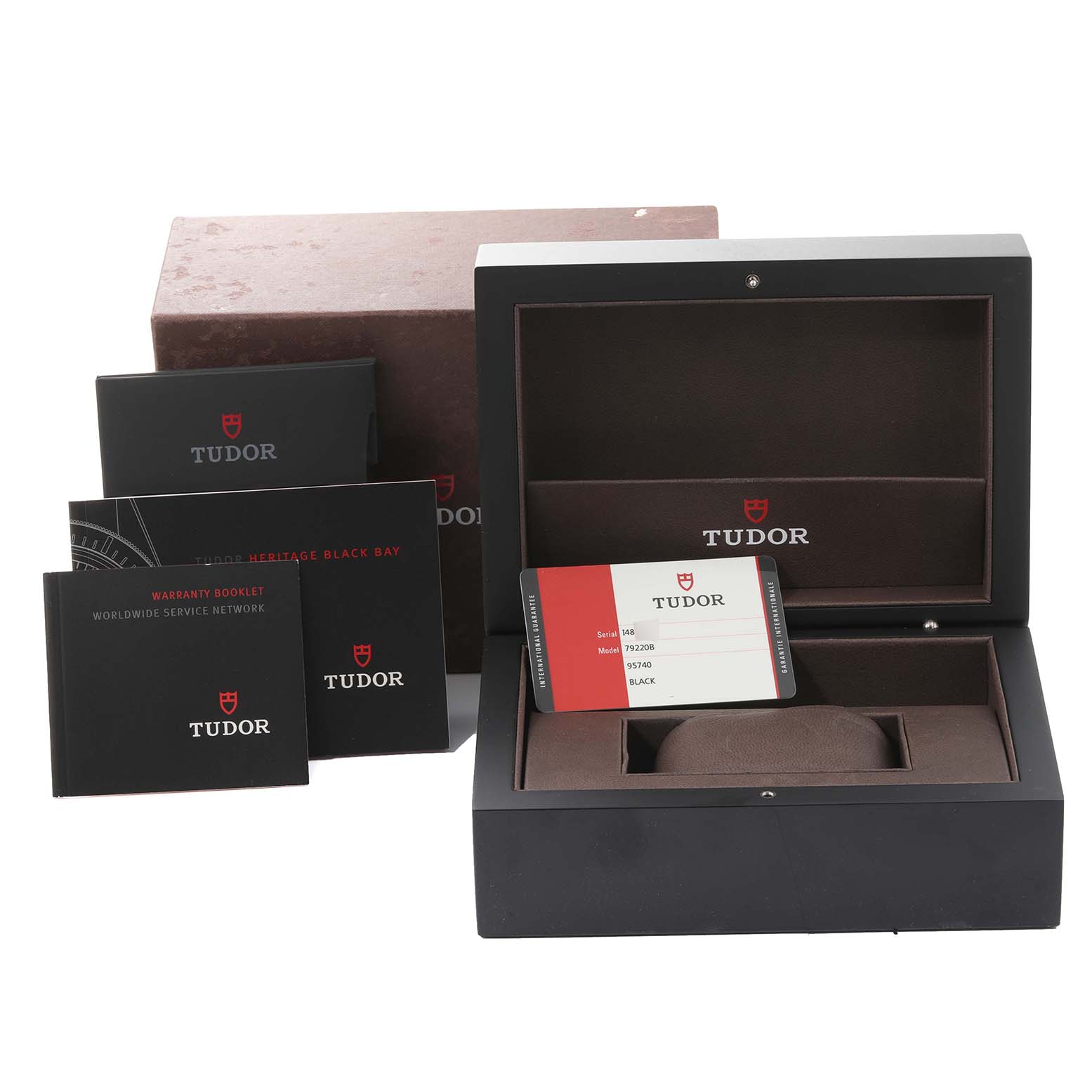 The image shows a Tudor Heritage Black Bay 79220B Men's Stainless Steel Black Dial 79220B Men's Stainless Steel Black Dial watch box, warranty booklet, instructions, and warranty card from a slightly elevated angle.