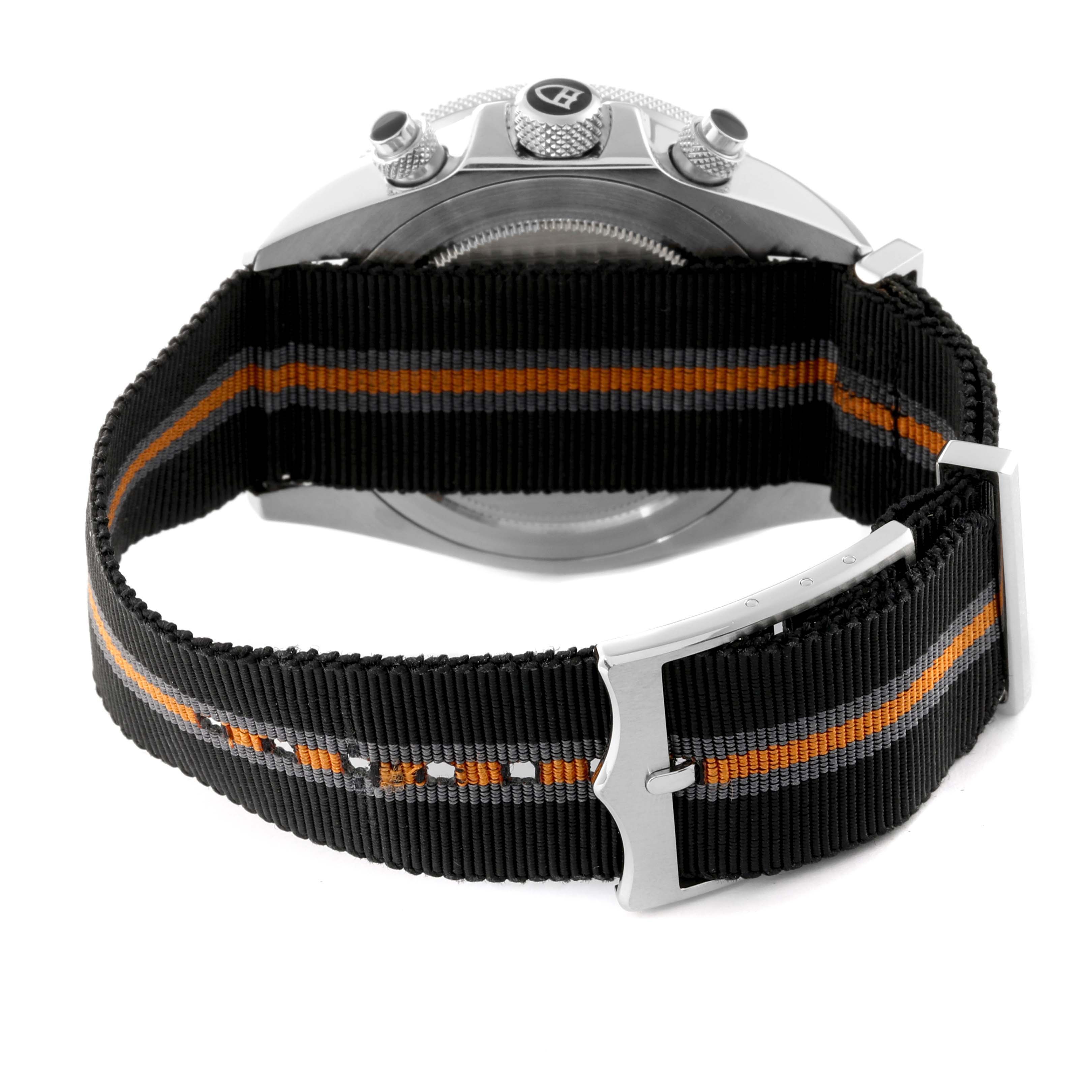 The image shows the back of a Tudor Heritage Chrono 70330N Men
s Stainless Steel Grey Dial 70330N Men
s Stainless Steel Grey Dial watch with a striped fabric strap and buckle.