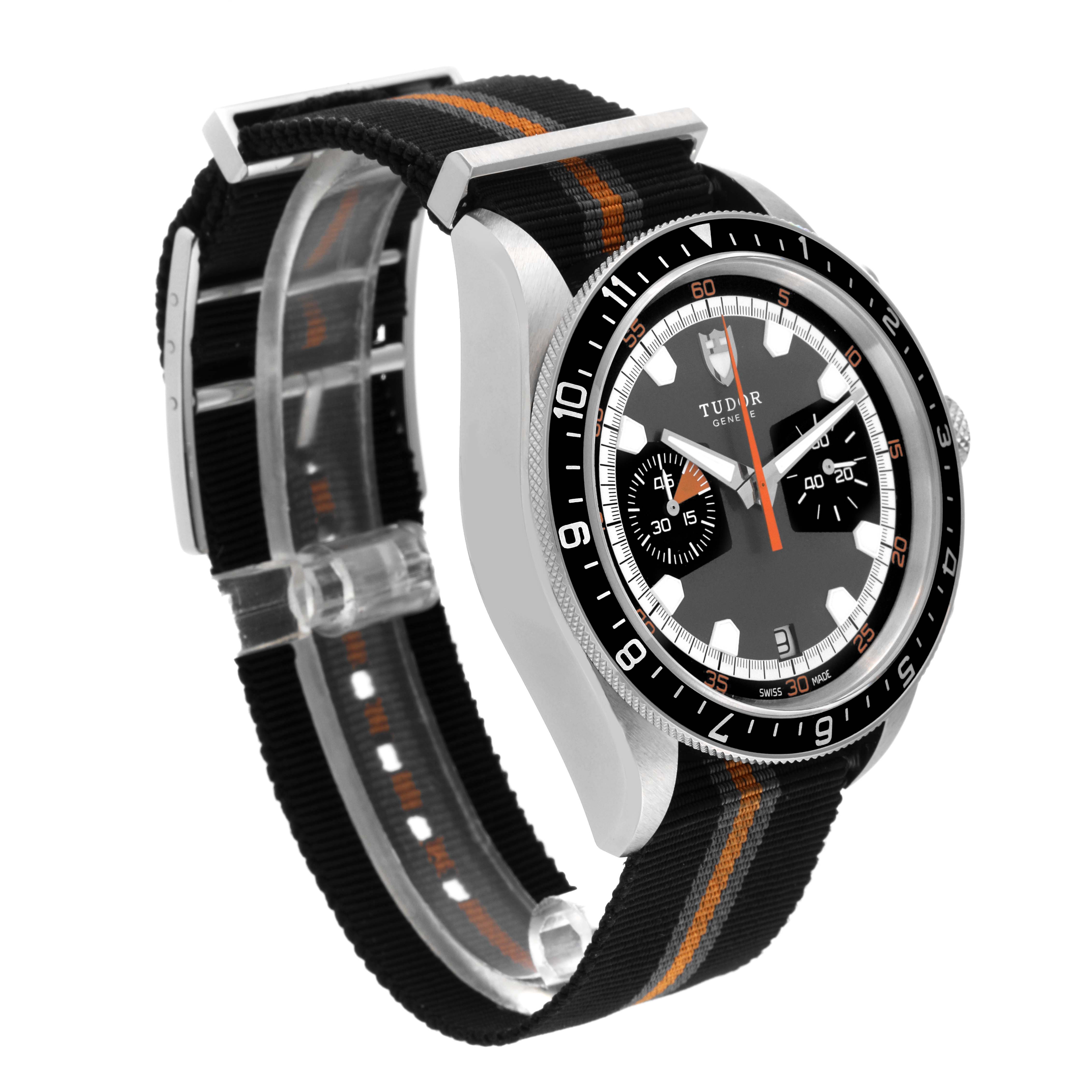The Tudor Heritage Chrono 70330N Men
s Stainless Steel Grey Dial 70330N Men
s Stainless Steel Grey Dial watch is shown from a three-quarter angle, highlighting its dial, case, and black and orange NATO strap.