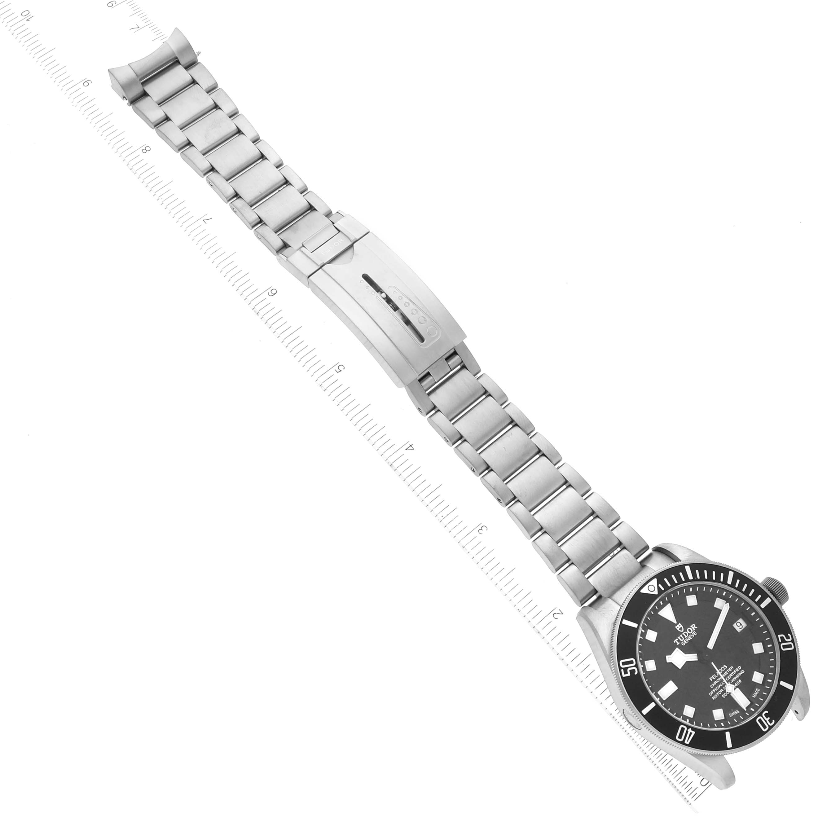 The image shows a Tudor Pelagos 25600TN Men
s Titanium Black Dial 25600TN Men
s Titanium Black Dial watch, displayed flat and measured on a ruler, featuring its black dial and metal bracelet with clasp.