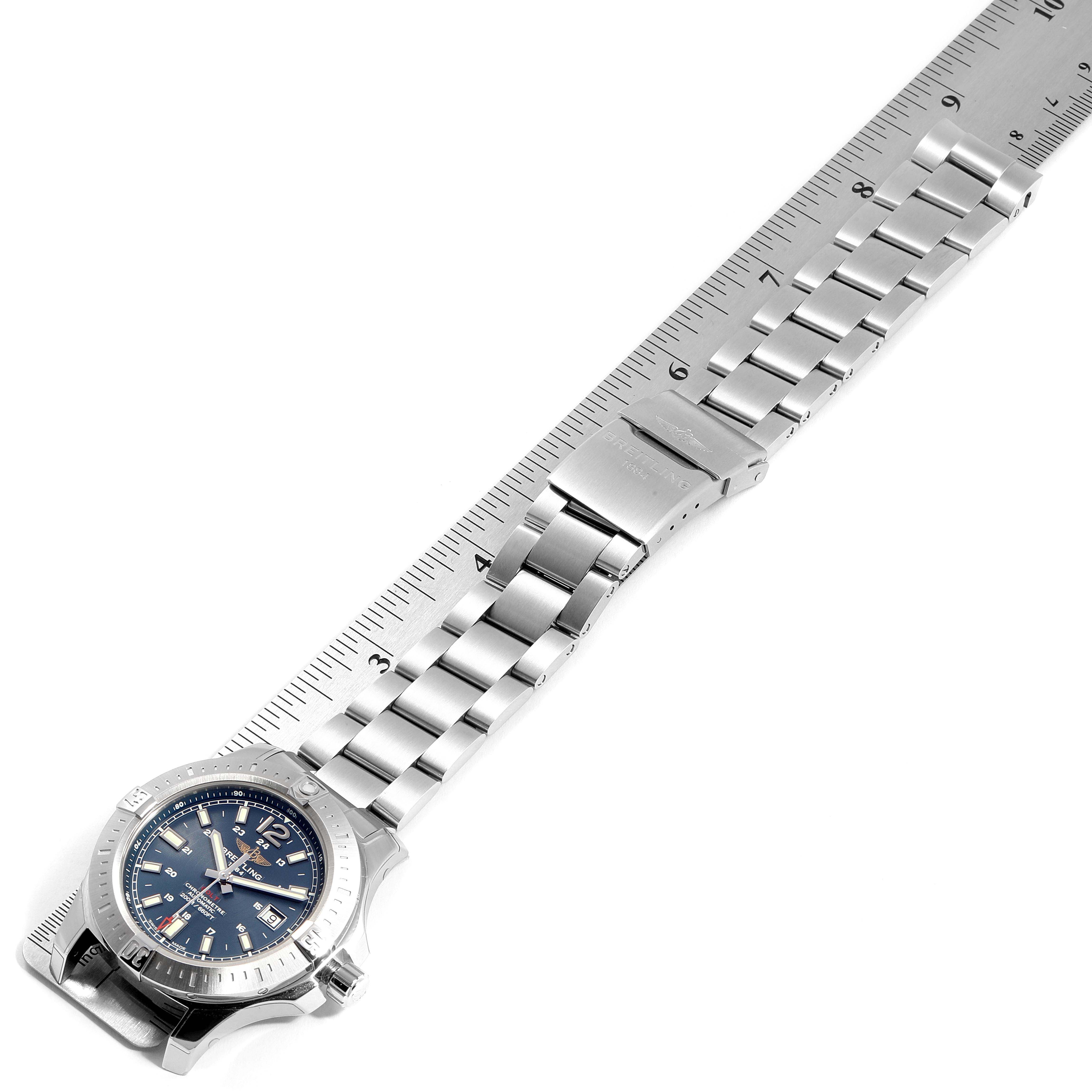 The Breitling Colt A17388 Men's Stainless Steel Blue Dial A17388 Men's Stainless Steel Blue Dial watch is shown from an overhead angle, showcasing its bracelet and clasp alongside a ruler for scale.