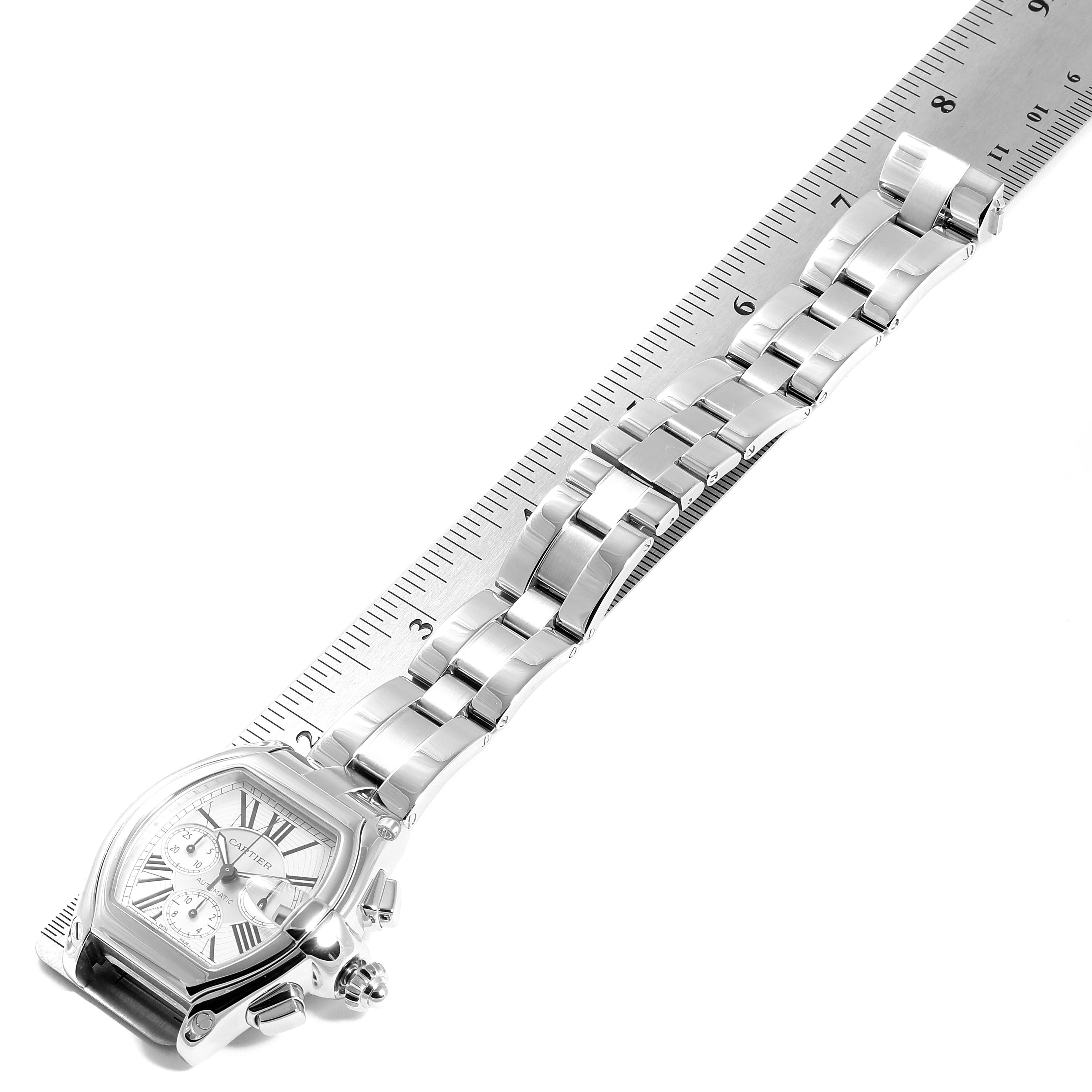 The Cartier Roadster W62019X6 Men
s Stainless Steel Silver Dial W62019X6 Men
s Stainless Steel Silver Dial watch is shown at an angled top view, displaying the face, links, and band alongside a ruler.