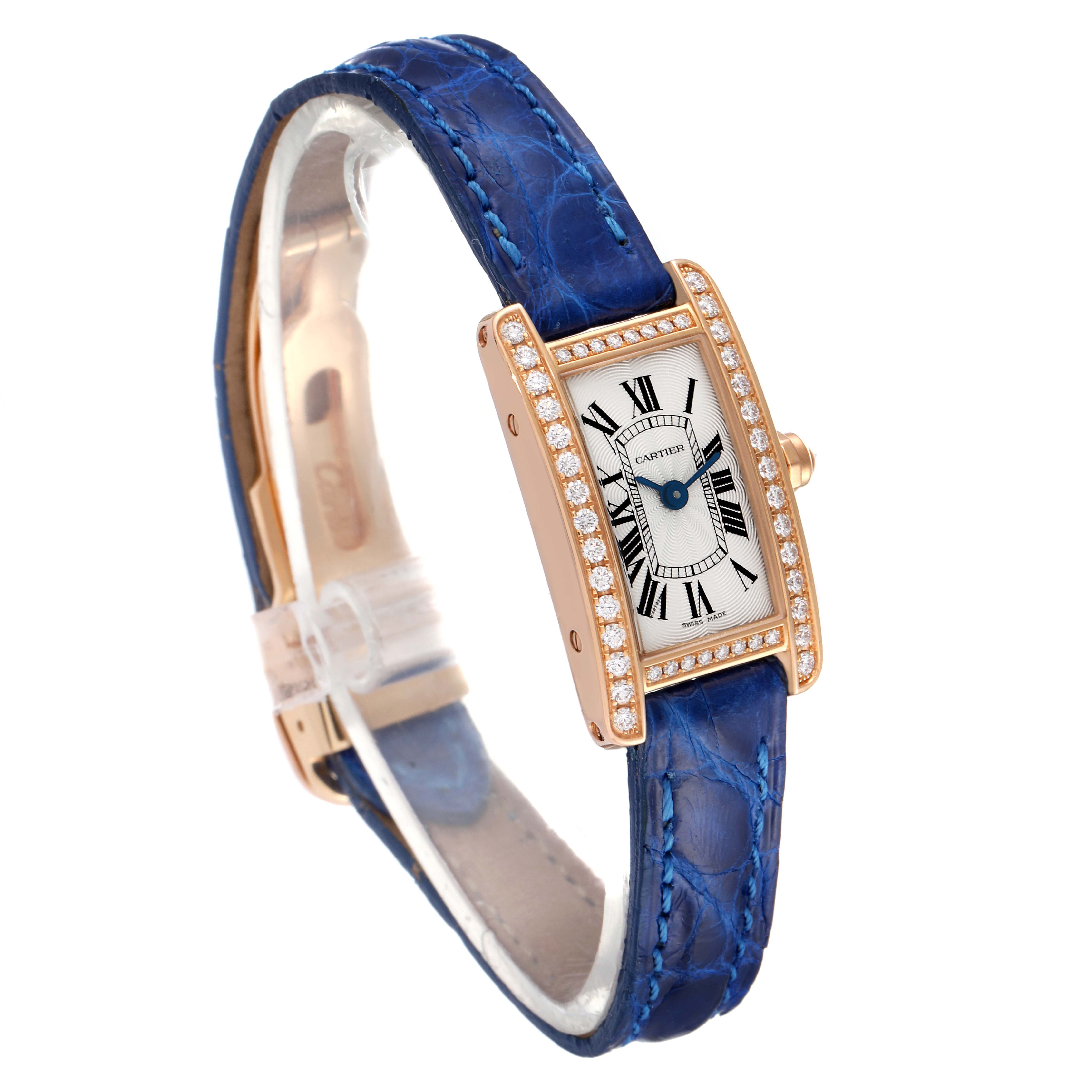 The Cartier Tank Americaine WJTA0026 Women's Rose Gold Silver Dial WJTA0026 Women's Rose Gold Silver Dial watch is shown at a three-quarter angle, highlighting its blue strap, rectangular dial, and gold case with diamonds.