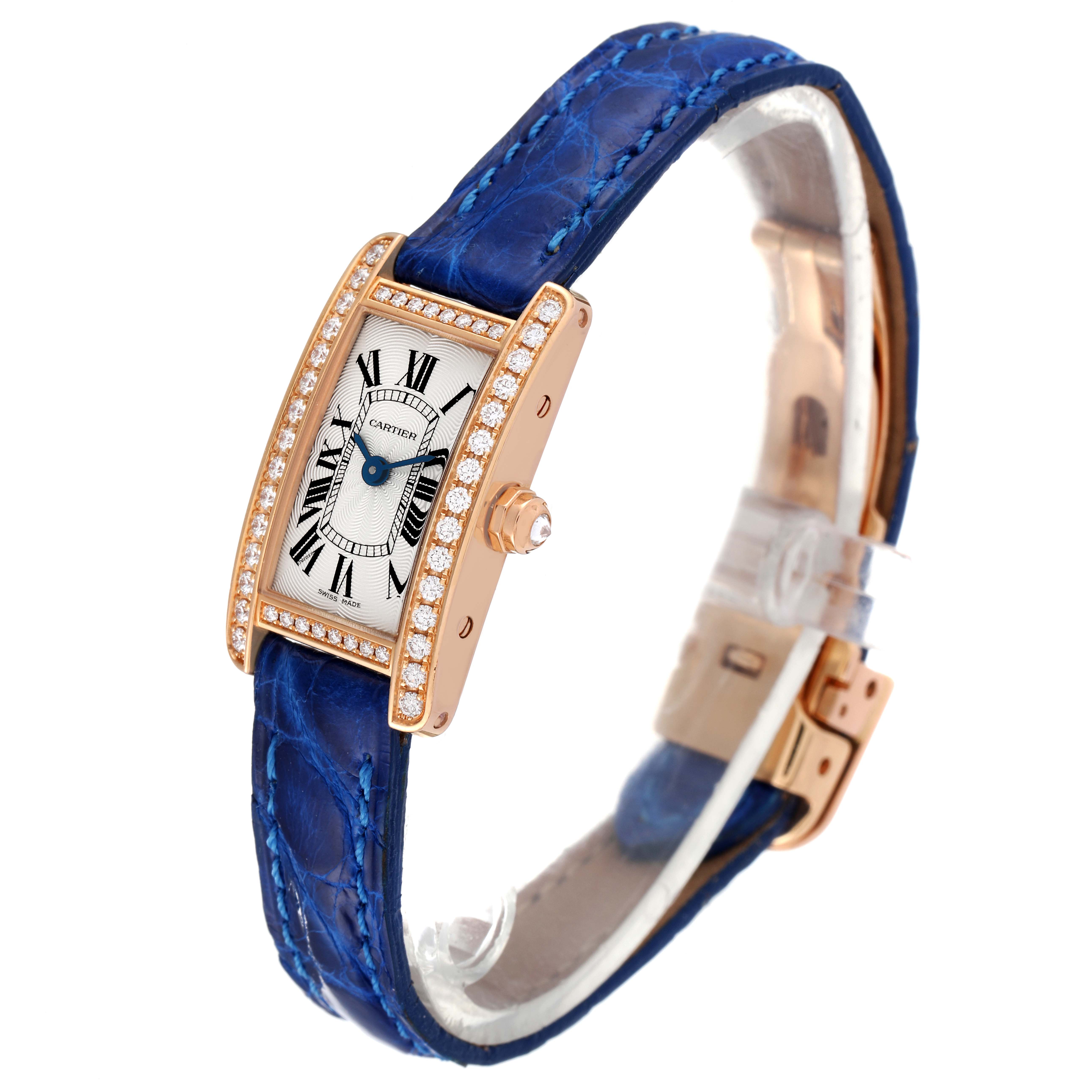 The image shows a Cartier Tank Americaine WJTA0026 Women's Rose Gold Silver Dial WJTA0026 Women's Rose Gold Silver Dial watch at a three-quarter angle, highlighting its blue strap, rectangular face, and diamond-encrusted bezel.