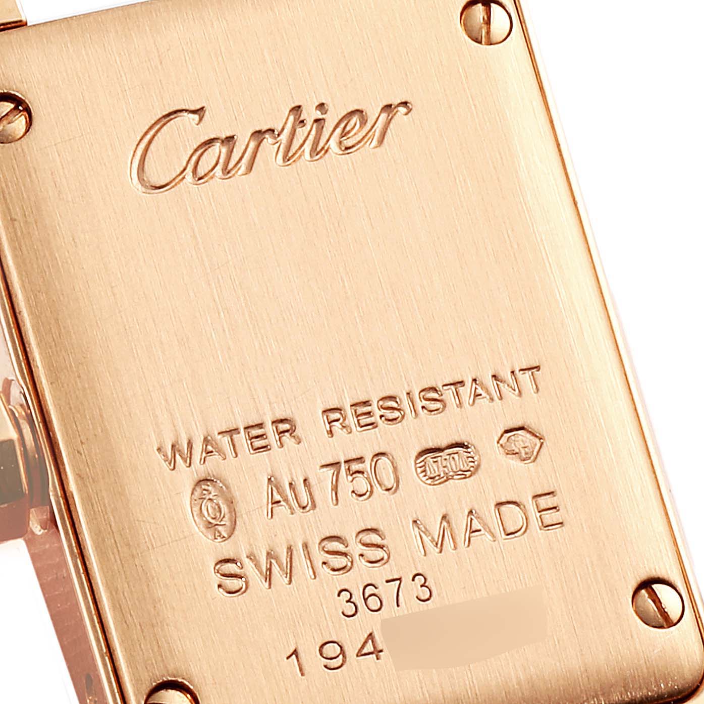 This image shows the back case of a Cartier Tank Americaine WJTA0026 Women's Rose Gold Silver Dial WJTA0026 Women's Rose Gold Silver Dial watch, highlighting brand engravings and specifications.