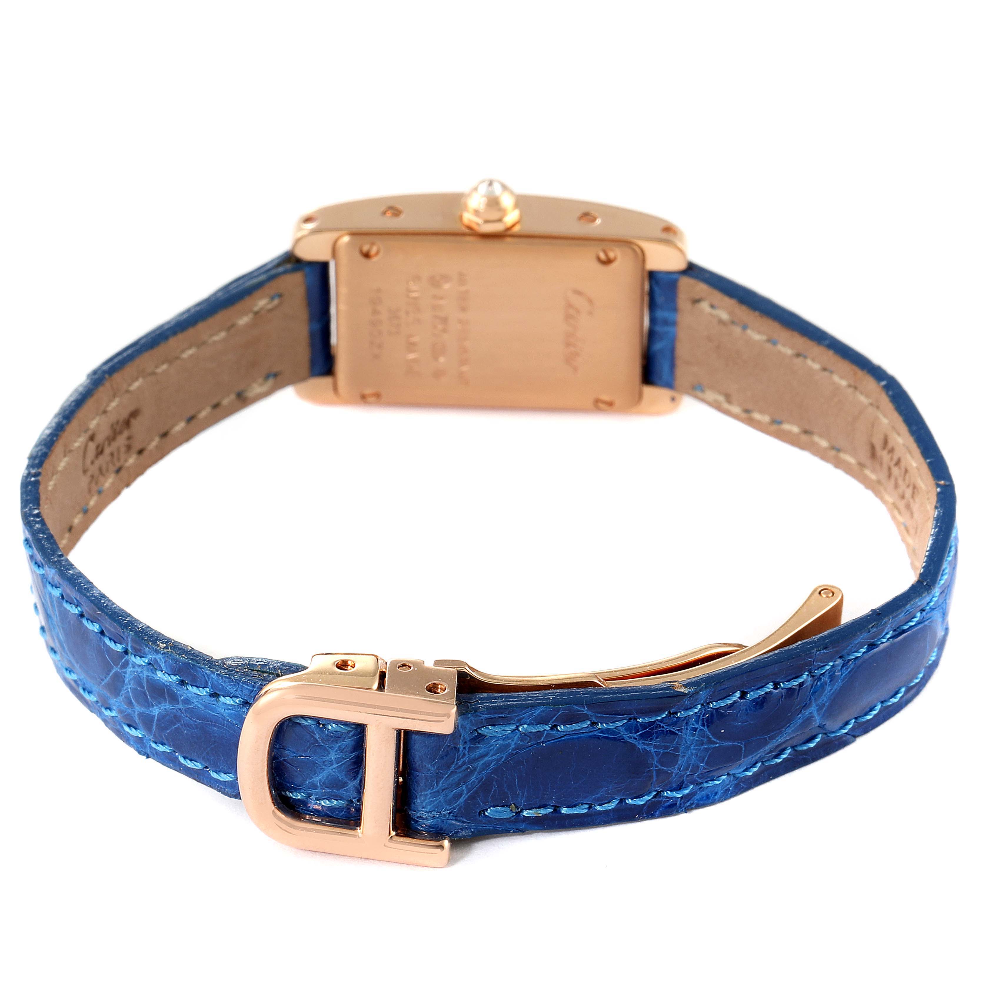 The Cartier Tank Americaine WJTA0026 Women's Rose Gold Silver Dial WJTA0026 Women's Rose Gold Silver Dial watch is shown from the back, featuring the watch case, blue leather strap, and buckle.