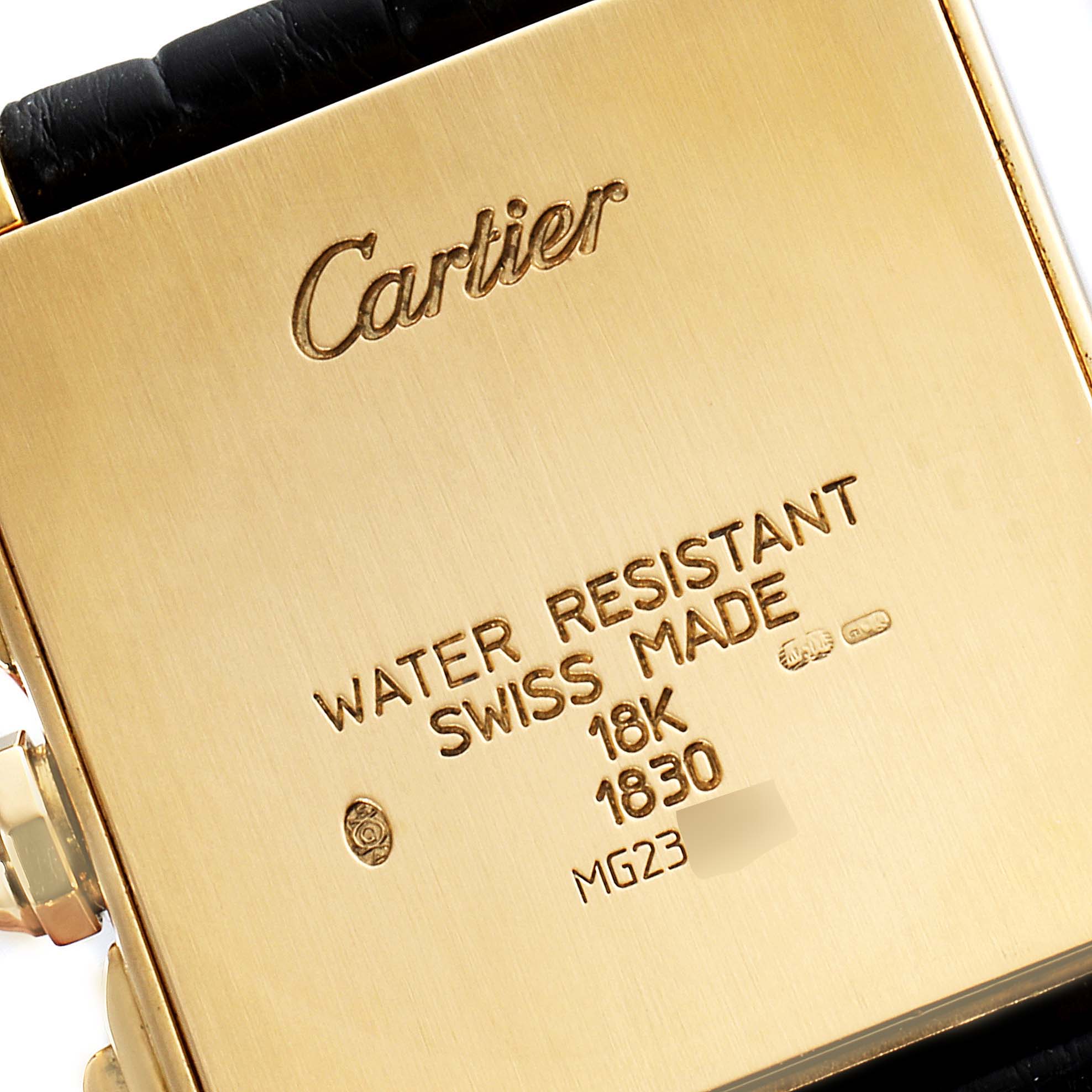 The image shows the back case and strap of a Cartier Tank Française watch with engraved details.