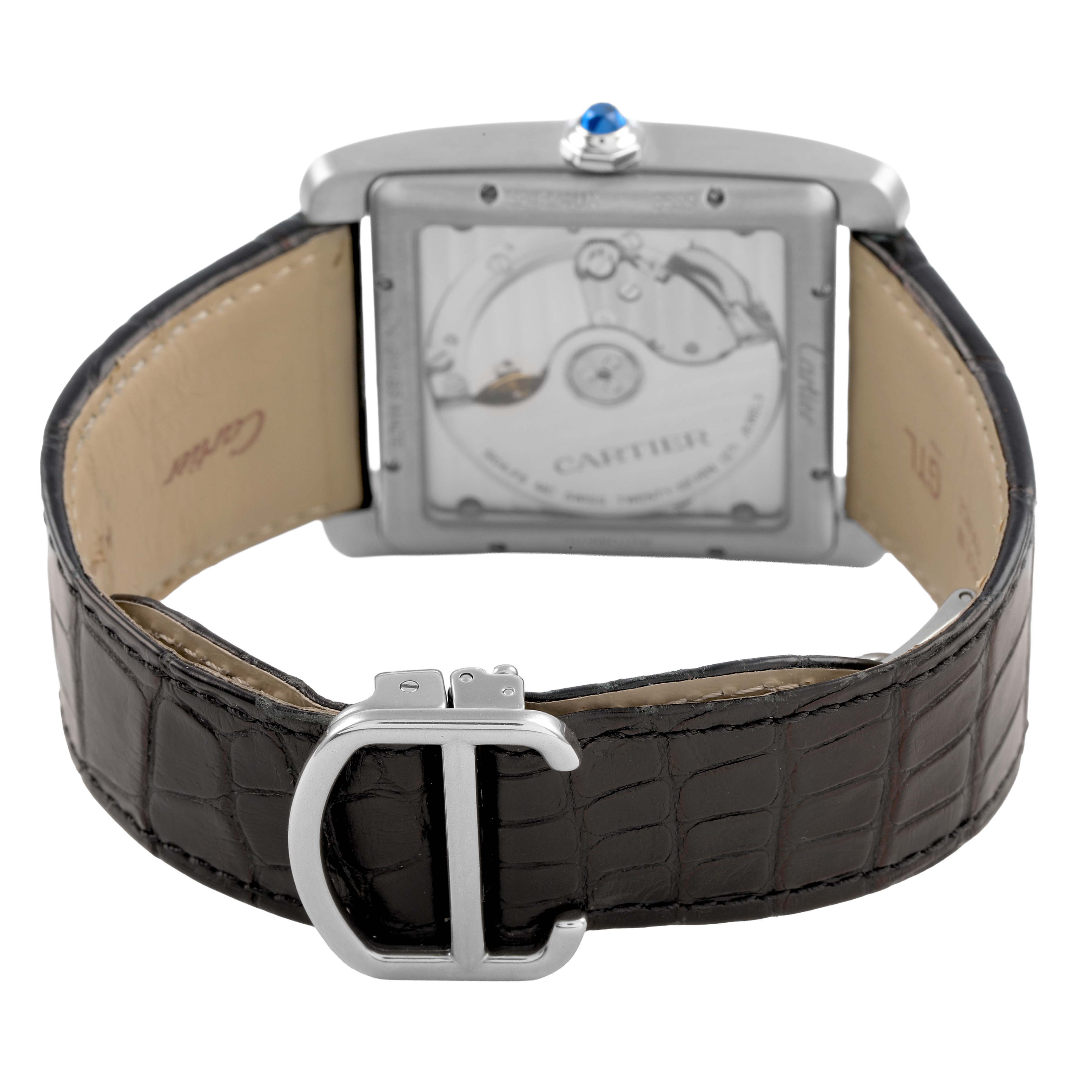 The Cartier Tank MC W5330003 Men's Stainless Steel Silver Dial watch is shown from the back, displaying the movement and leather strap with a visible clasp.