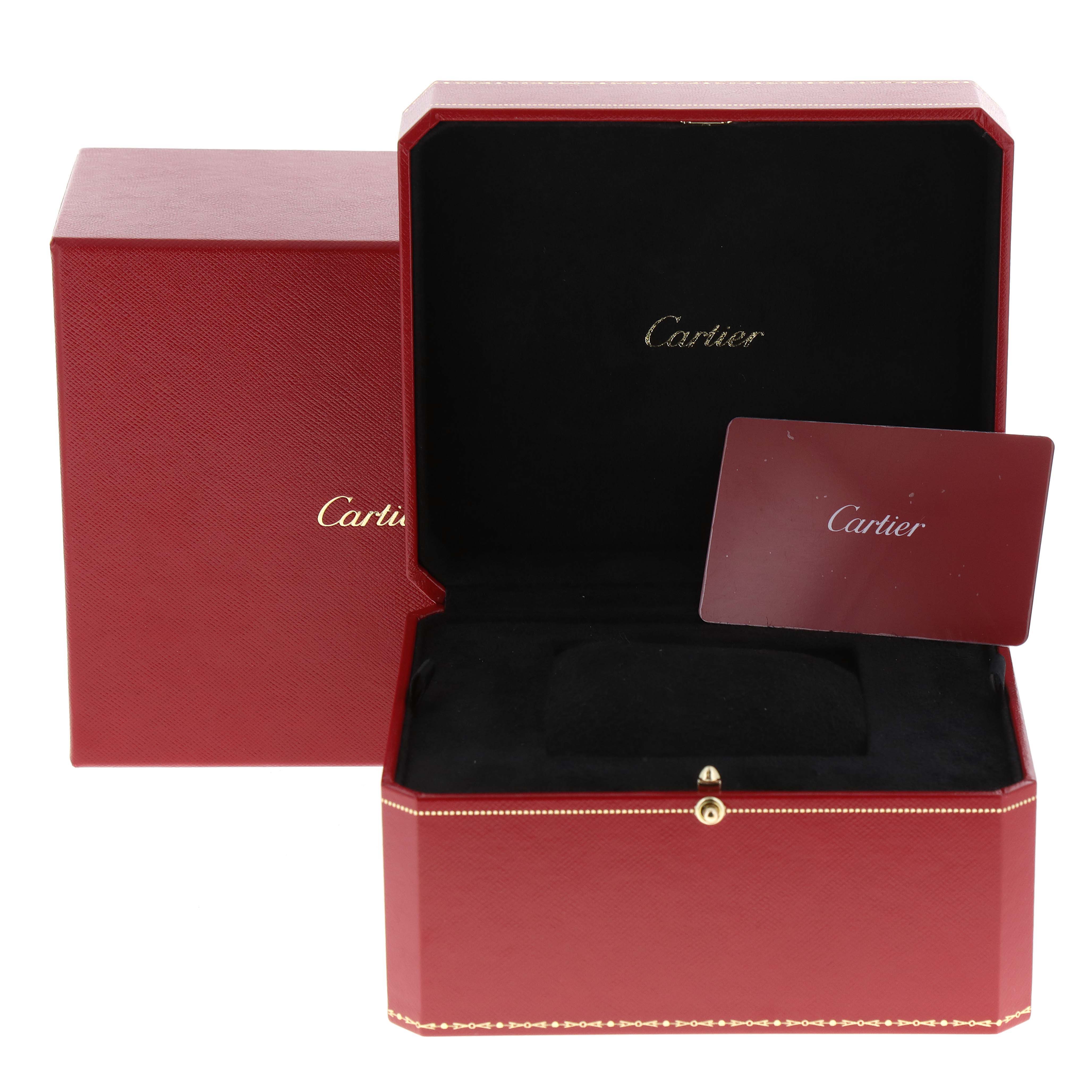 The image shows a red Cartier box and card for the Tank Must model, with the box slightly open.